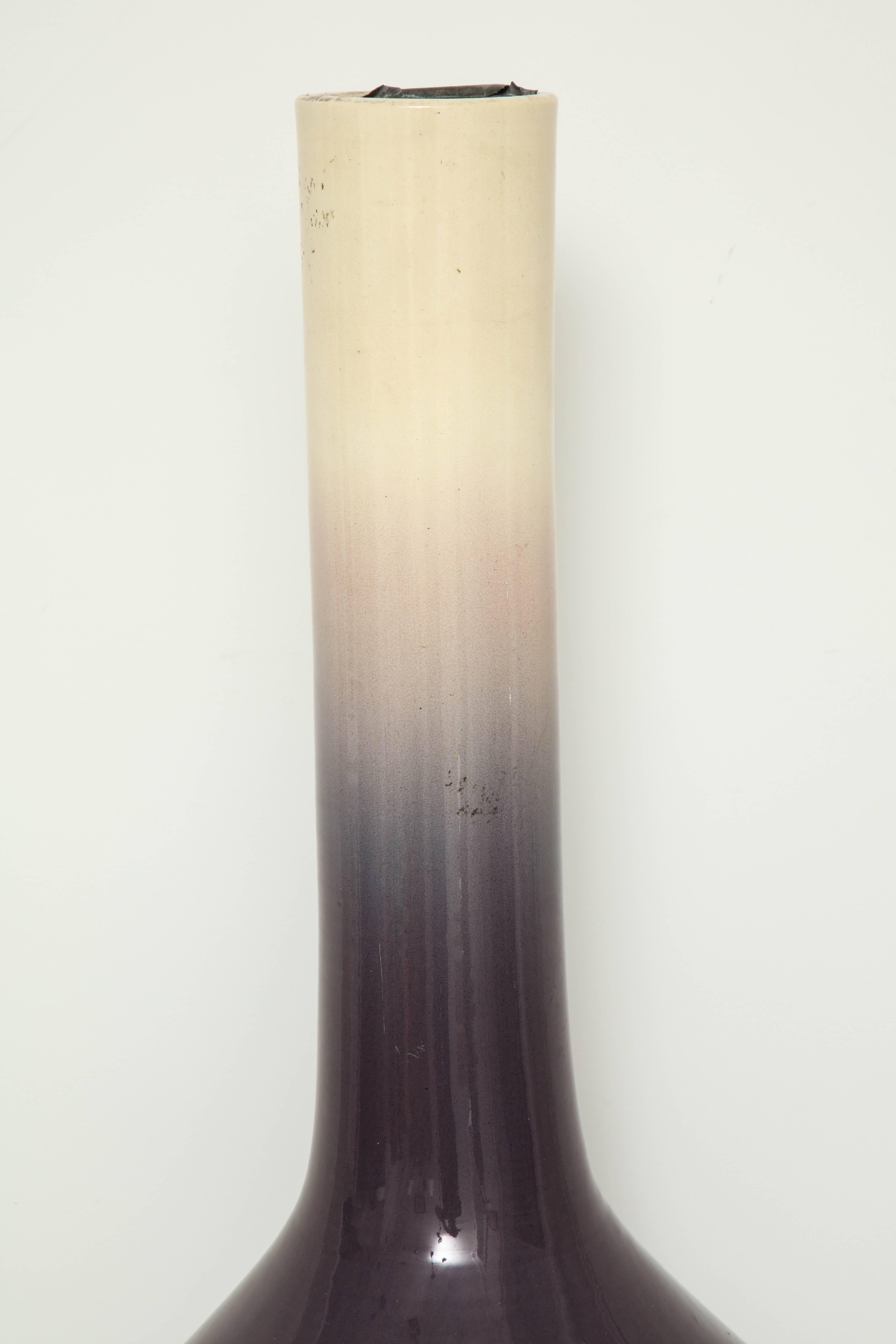 An exceptionally large Chinese flambé glazed vase with ombre coloring from deep purple to bisque. There is a removable metal insert to hold water in the neck of the vase.