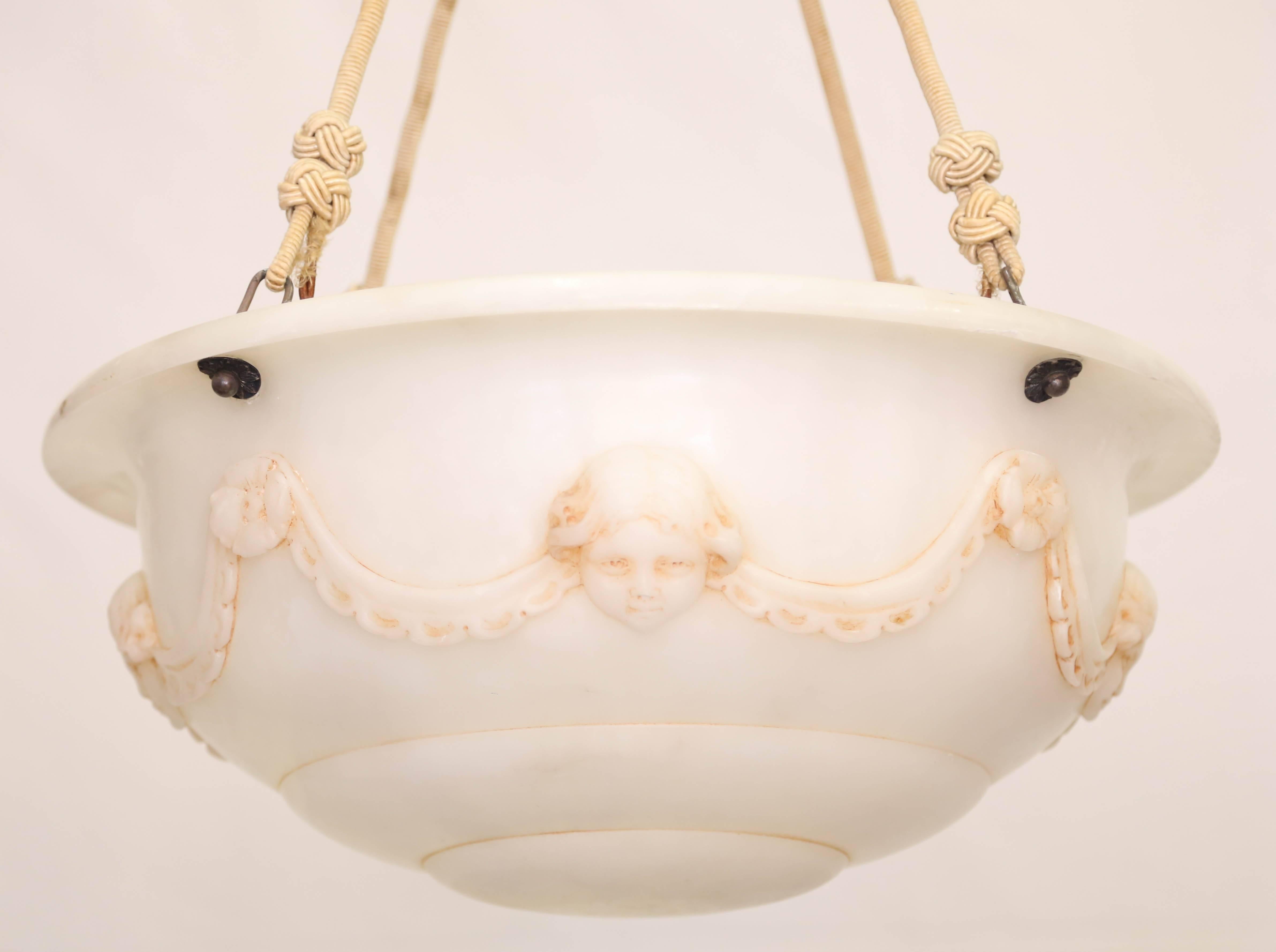 With alabaster canopy and silk cords suspending the beautifully carved chandelier with putti and a swagger garland. Takes eight 75watt chandelier bulbs.