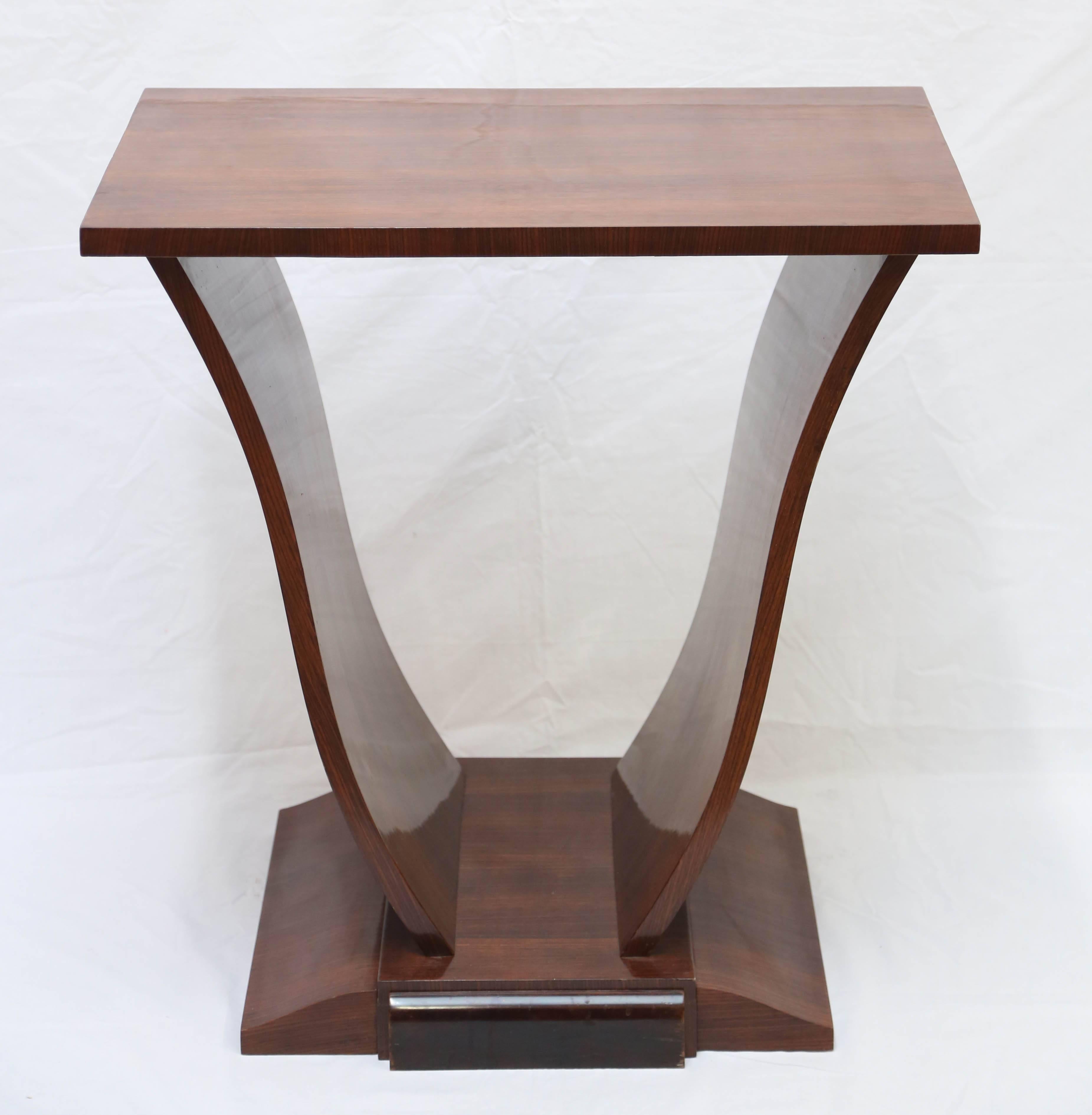 The rectangular top over side supports on a plinth base with ebonized detail. Lovely French polish and warm color to walnut.