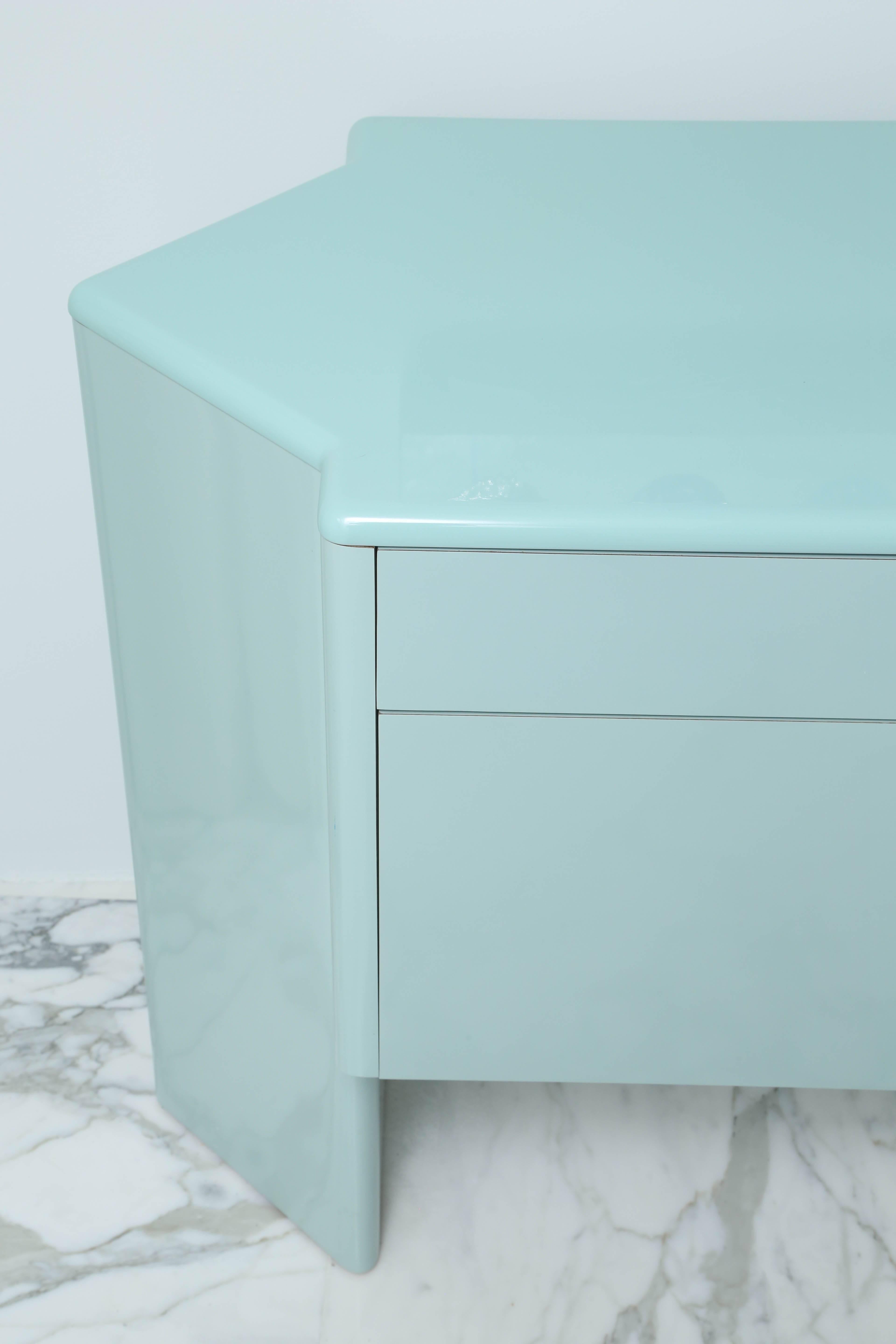 Custom cabinet lacquered in robin's egg blue; fitted with four drawers over four cabinet doors.