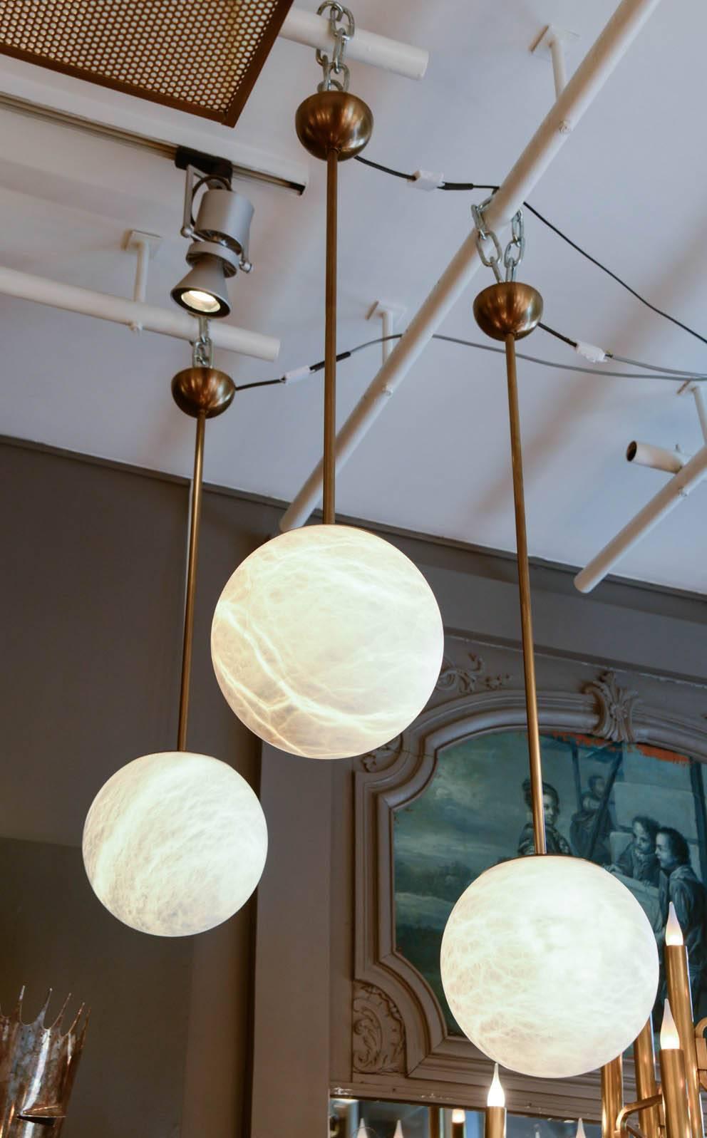 New design by Glustin Luminaires, these very elegant and simple pendant made of patinated brass stem holding an alabaster globe.

 