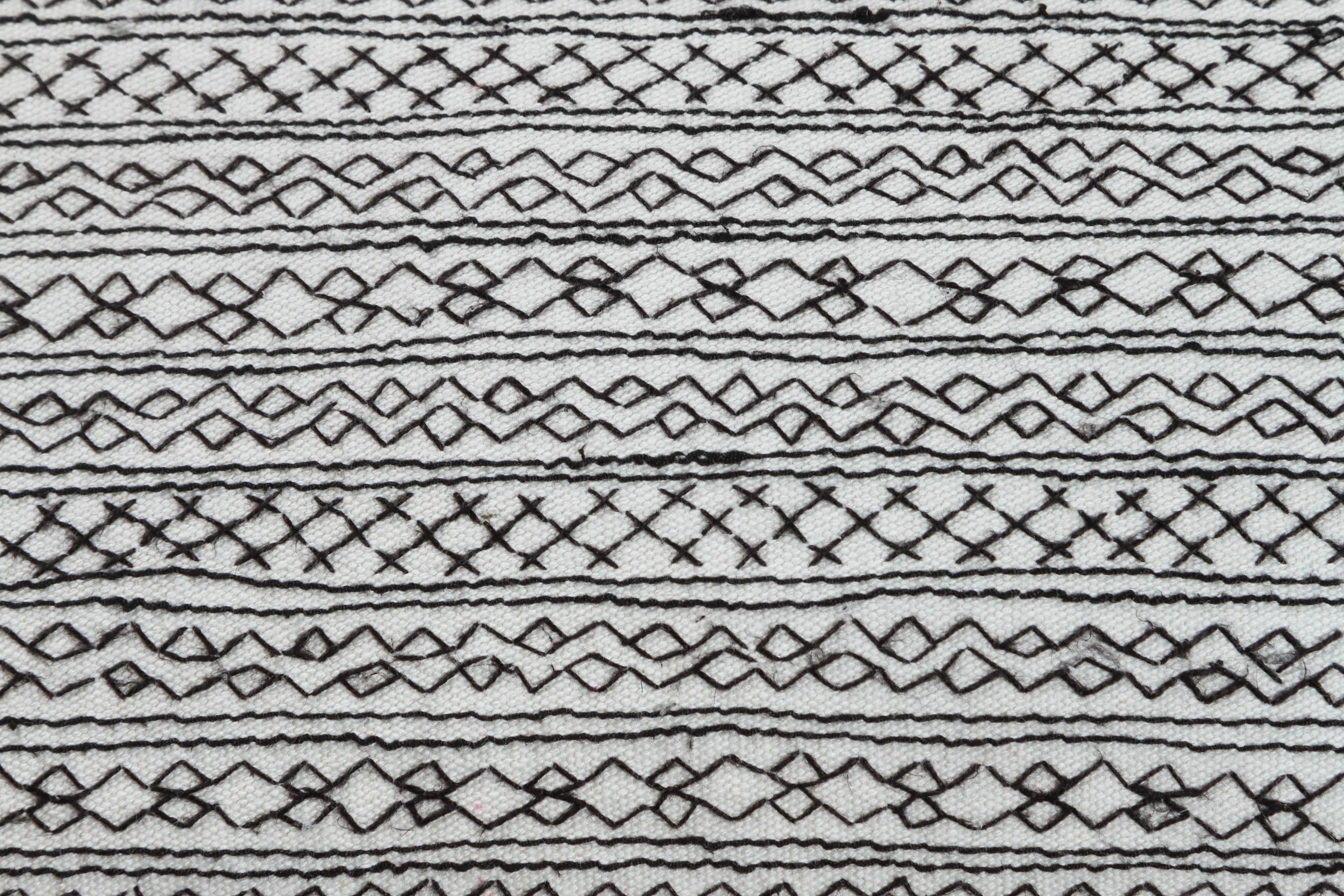 Vintage cotton on cotton embroidery producing a heavy quilted effect. Black stitching on handwoven white cotton. Zig zag and geometric stripes. Made as a tunic in Nuristan, Afghanistan. Black linen backing. Feather and down fill, invisible