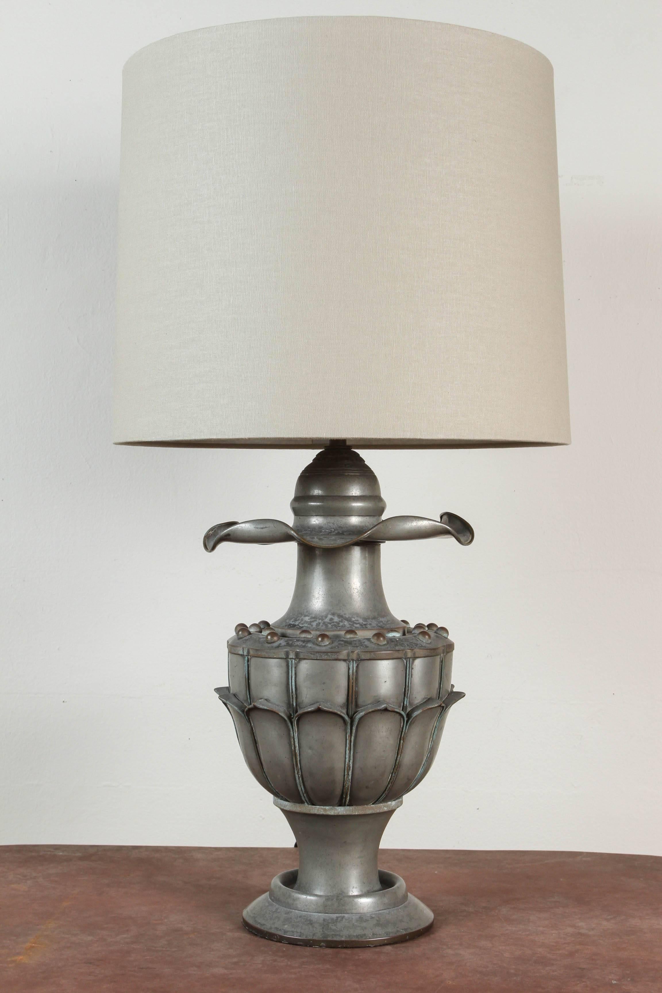 Early 20th century Chinese zinc work table lamp. Original triple cluster with pull chain sockets has been updated and rewired with black silk European style twist cord. Custom taupe linen shade with diffuser. Original finial.