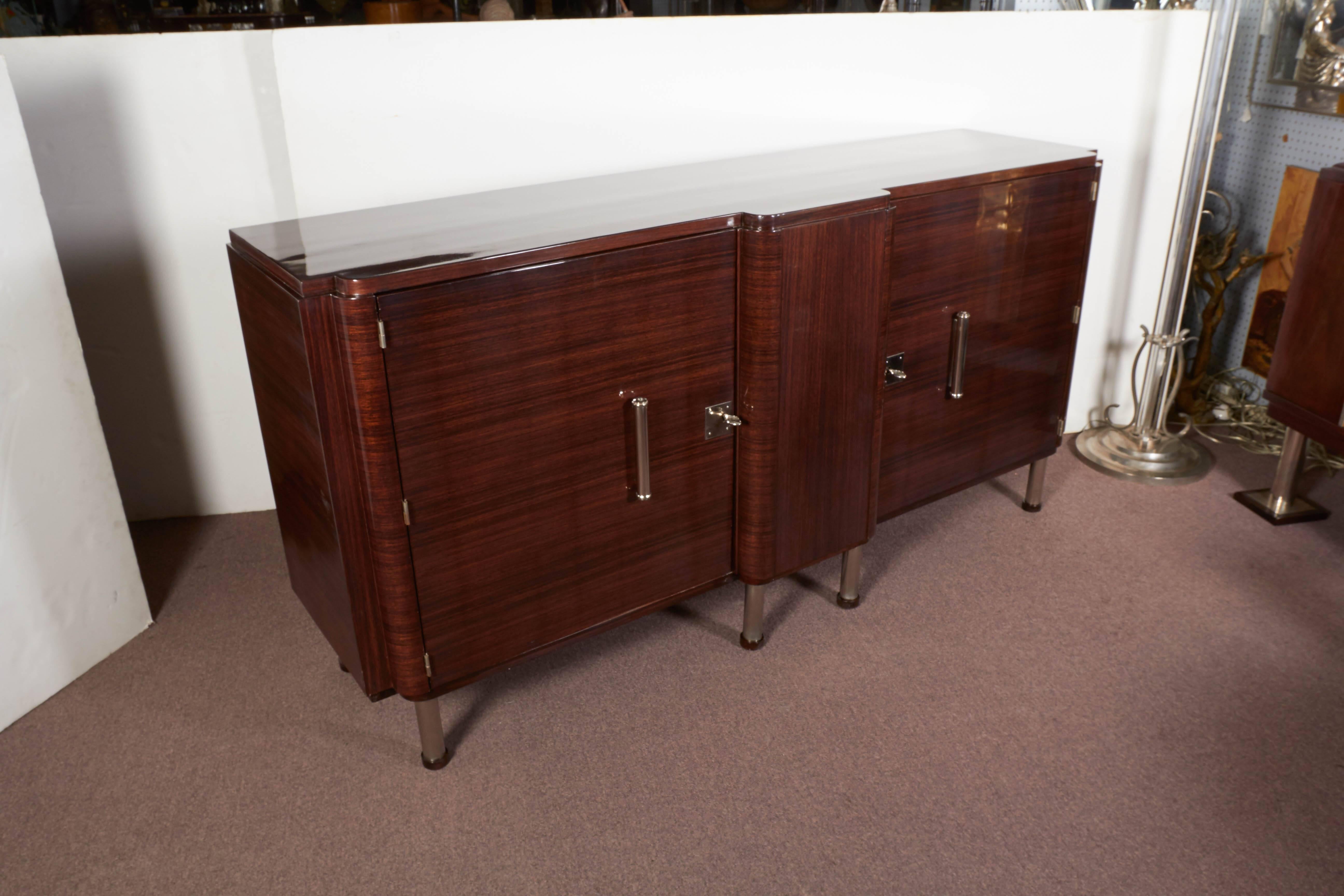 French Modernist sideboard in exquisite palissander showing fine detailed craftsmanship.
The wood grain runs horizontal while the cabinet boasts square edges cornered by radius curves, a lovely bullnose front and nickeled bronze mounts. The hardware