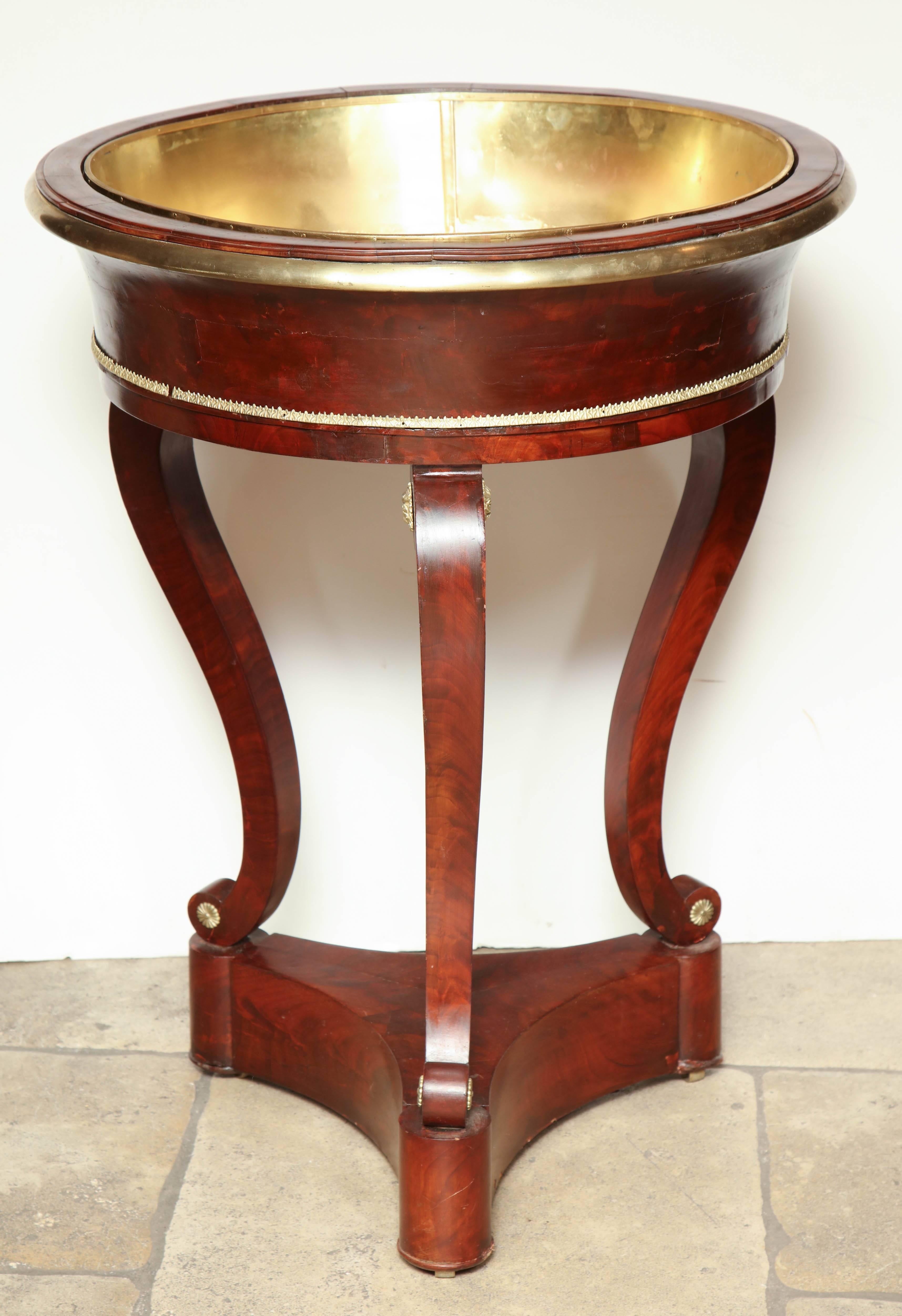 A large French Empire mahogany Jardinière with brass lining, brass trim and mounts on a tripartite plinth base.