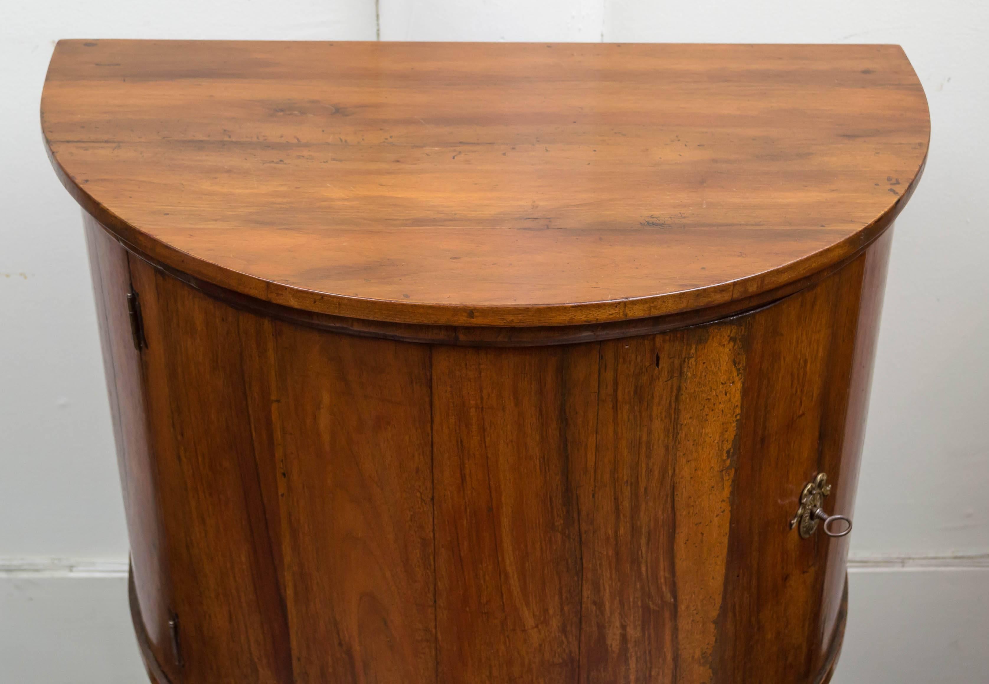 Italian walnut neoclassic demilune cabinet, circa 1790. Solid walnut top and front with contrasting figure to the boards. Splayed legs are reinforced and sturdy. A good small-scale size cabinet that can be used in a number of places.
Working lock
