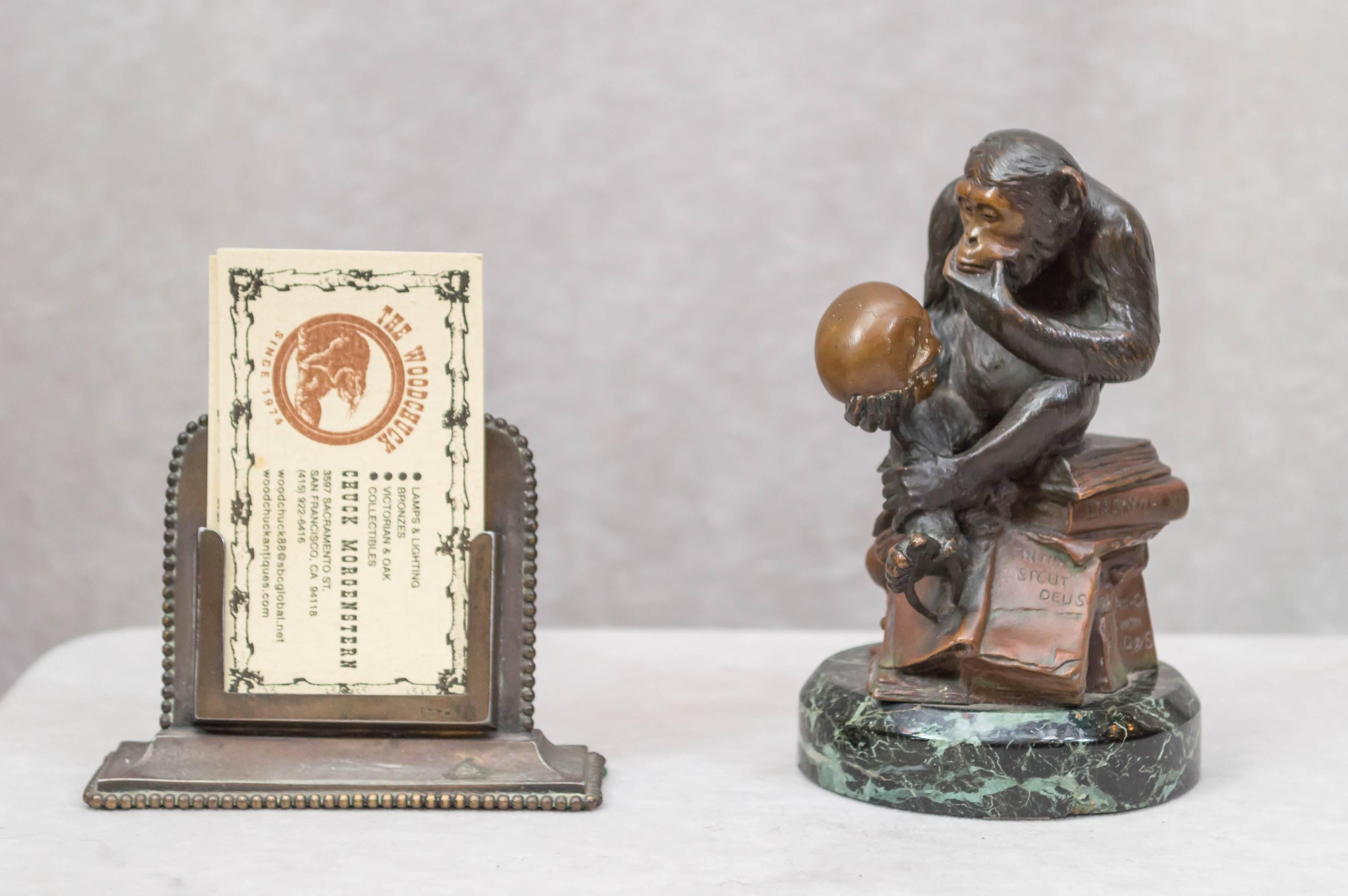 This captivating bronze is indeed the height of whimsy. The seated monkey studies the skull while sitting atop a stack of books including the works of Charles Darwin. He is wondering whether he is an ancestor to the human species. Please note how