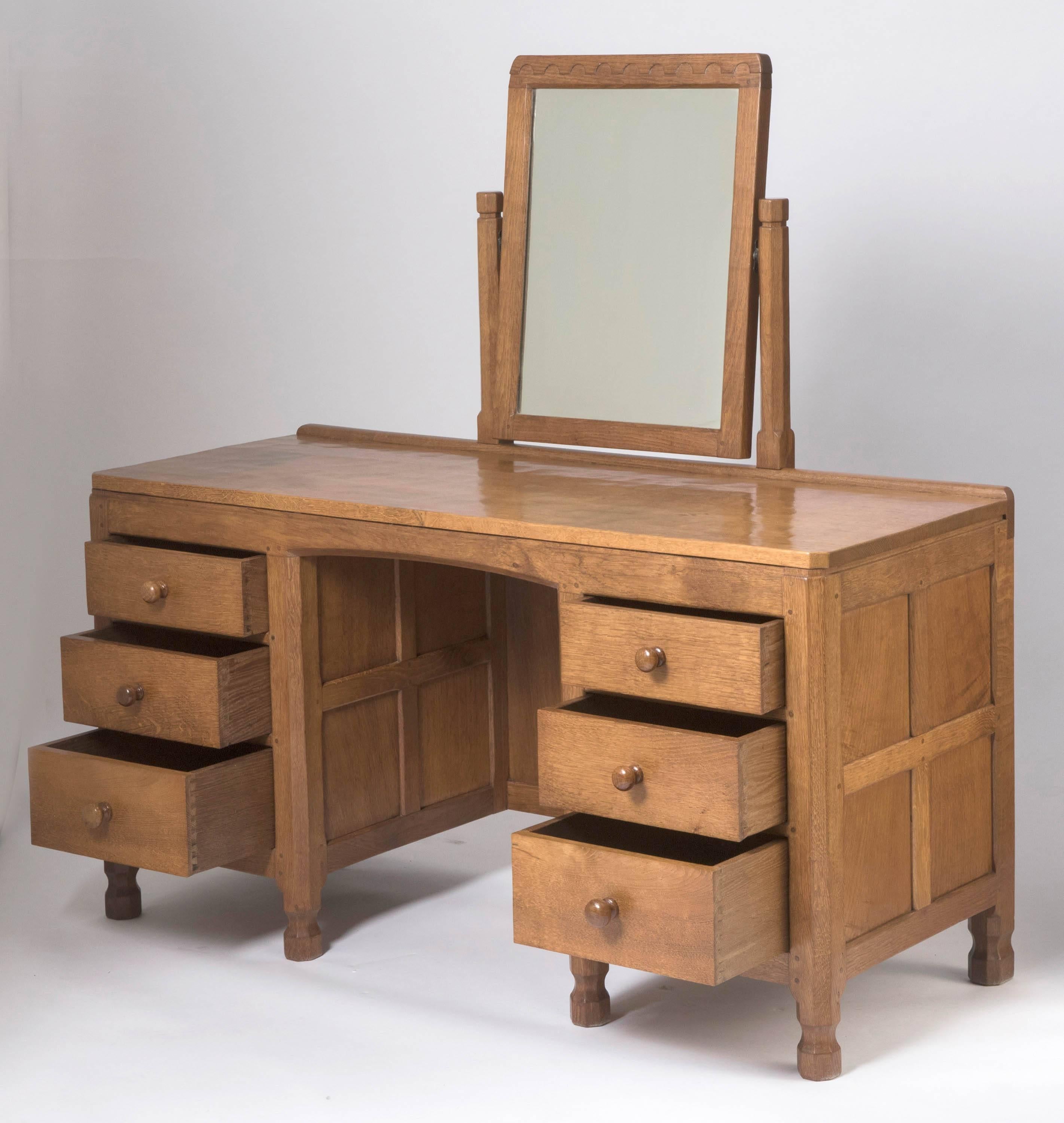A rare and early oak dressing table by Robert “Mouseman” Thompson
Beautifully adzed.
The rectangular mirror supported on two octagonal shaped columns.
The adzed top above a central knee hole with three drawers each side.
On wasted octagonal