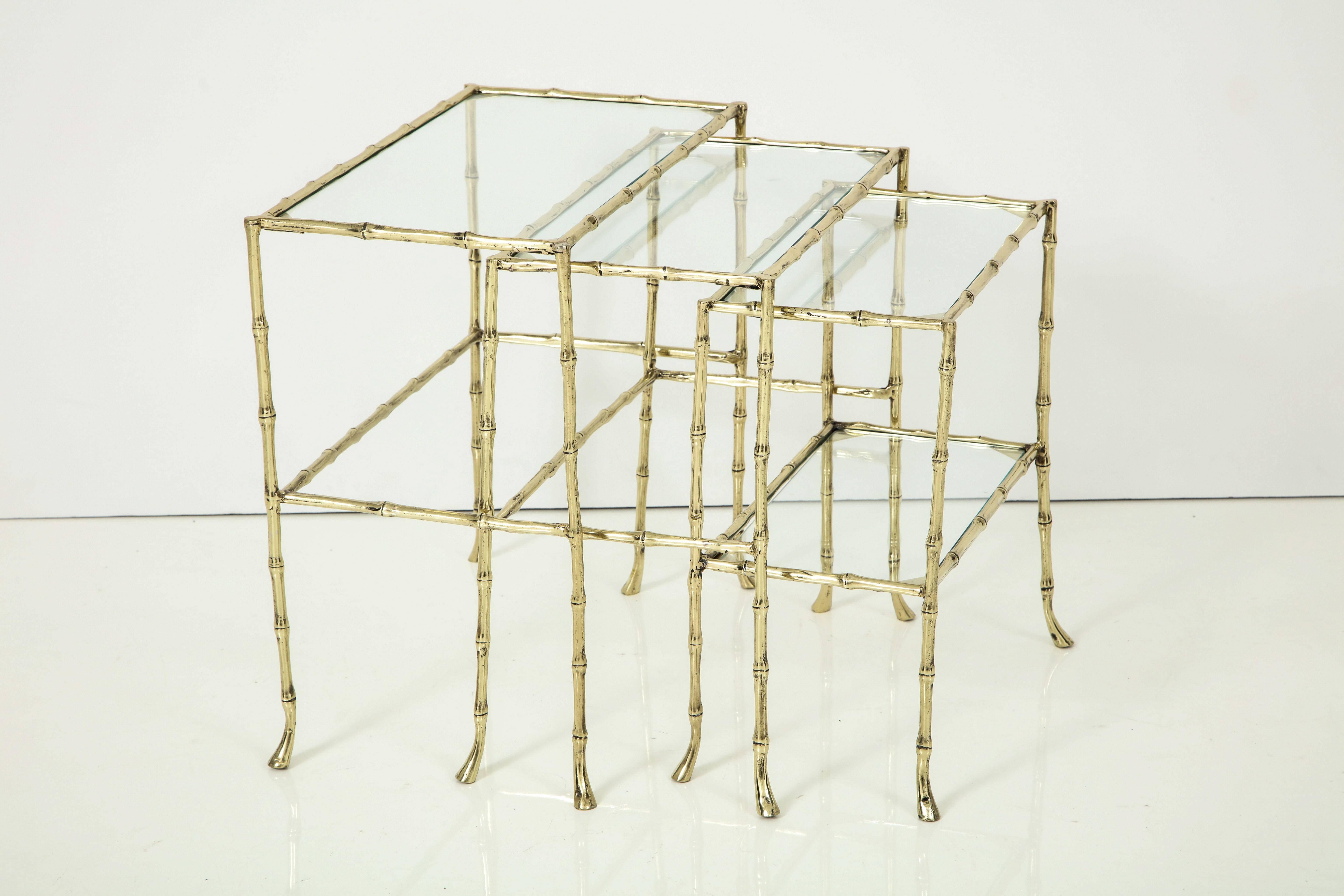 Set of three faux bamboo nesting tables with glass tops.