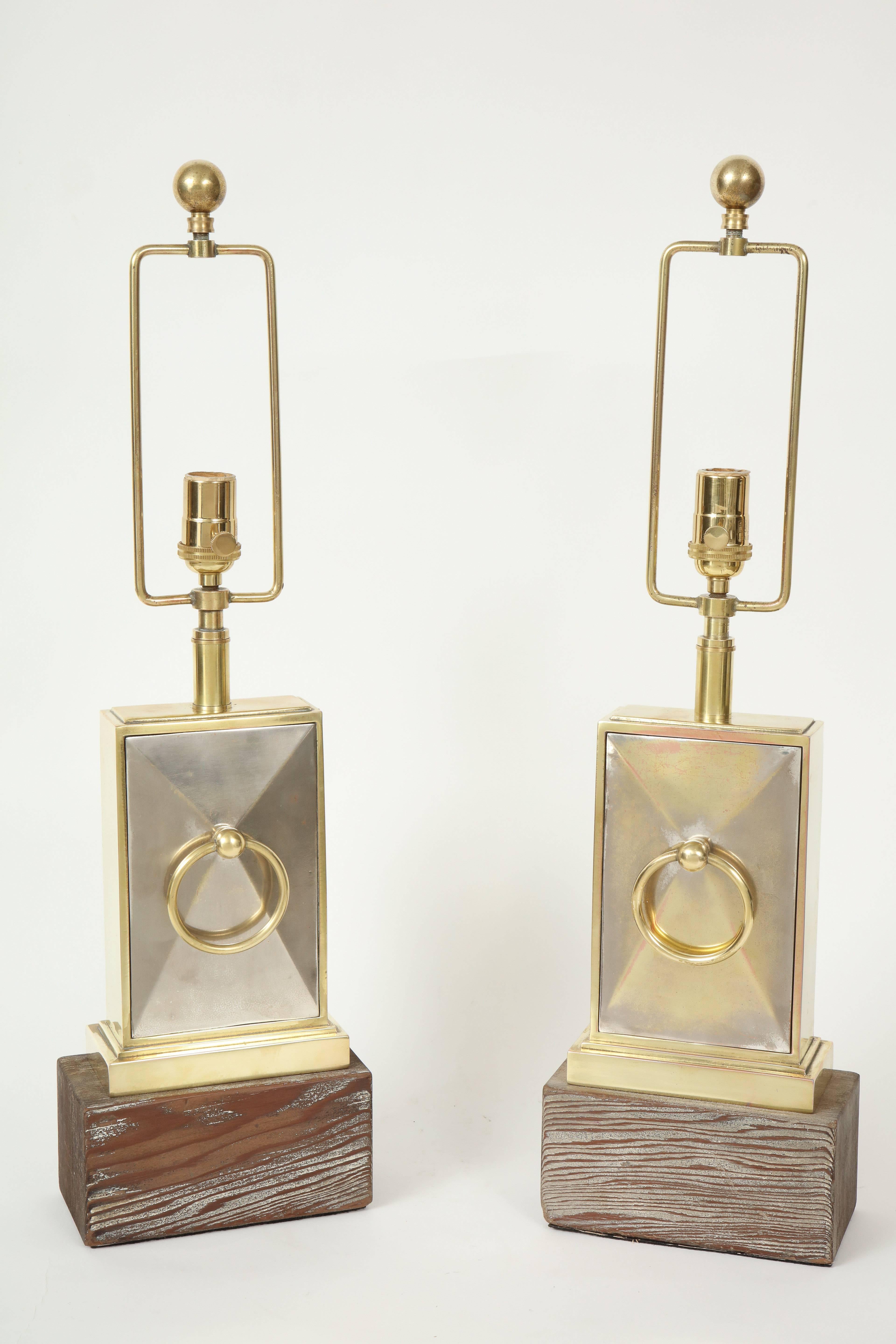 Pair of lamps by James Mont.
The faceted nickel lamp bodies are framed in brass with ornamental ring.
They sit up on wooden bases which have a pickled oak finish and are newly rewired for the US.
The height to the top of the lamp body is 13