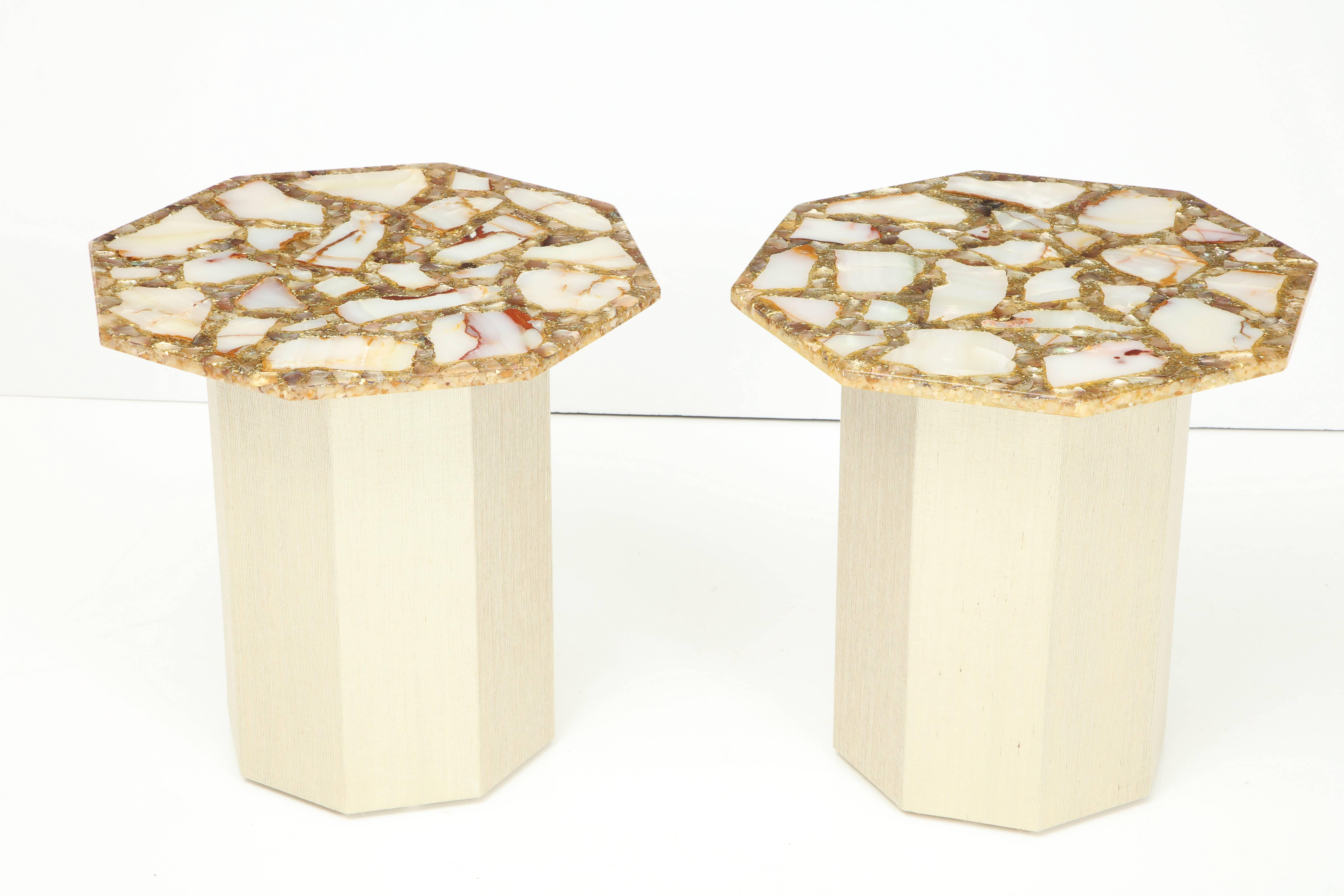 A stunning pair of vintage agate and gold dust octagonal side tables.
The vintage tops are set on new custom octagonal bases which are
upholstered in a rich Romo grass cloth which has gold threading to complement the tops.