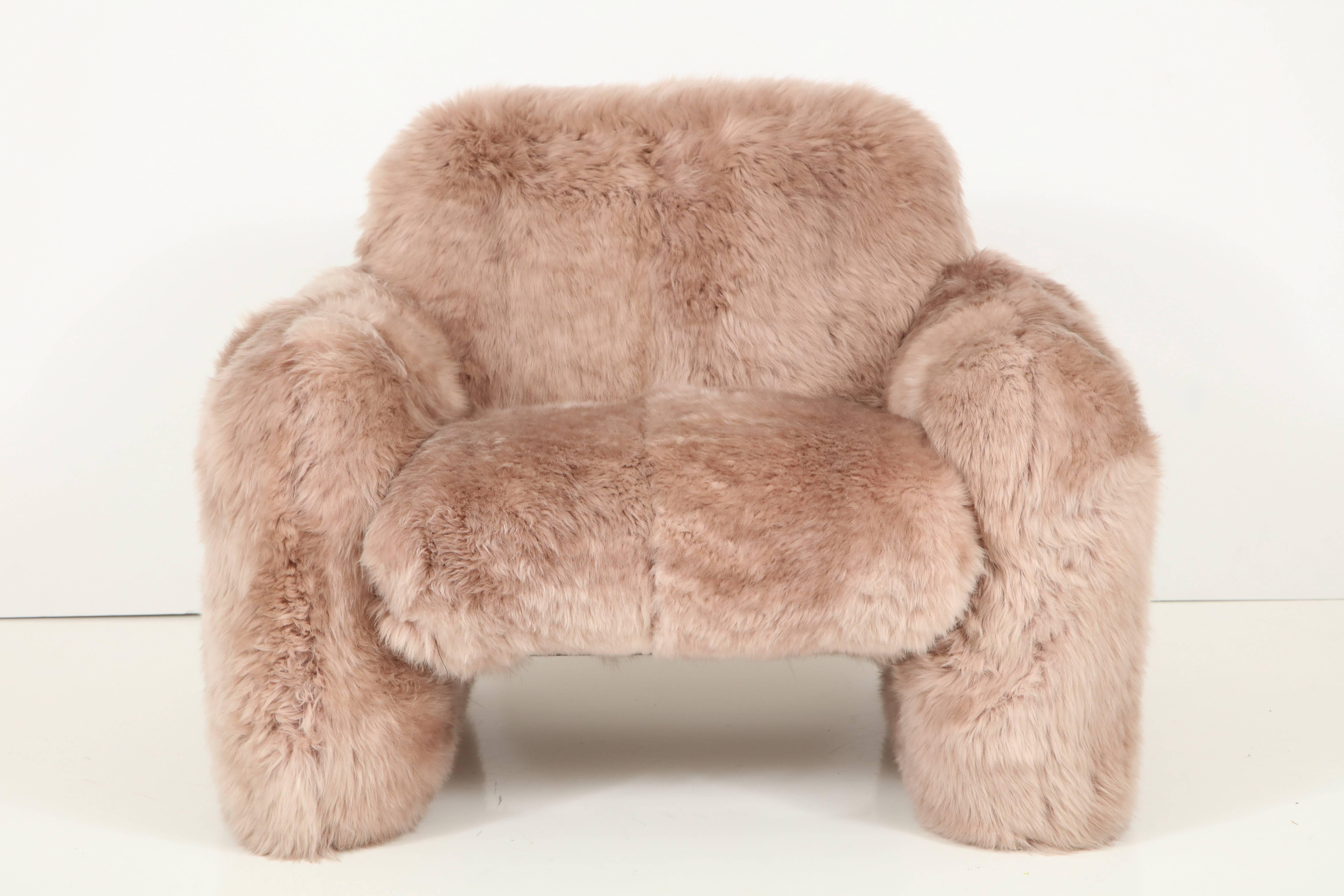 Dramatic and luxurious pair of club chairs upholstered in sandstone colored New Zealand sheepskin. The simplistic forms are the perfect platform to showcase the incredible soft and dense sheepskins. Chair frames are well constructed steel frames