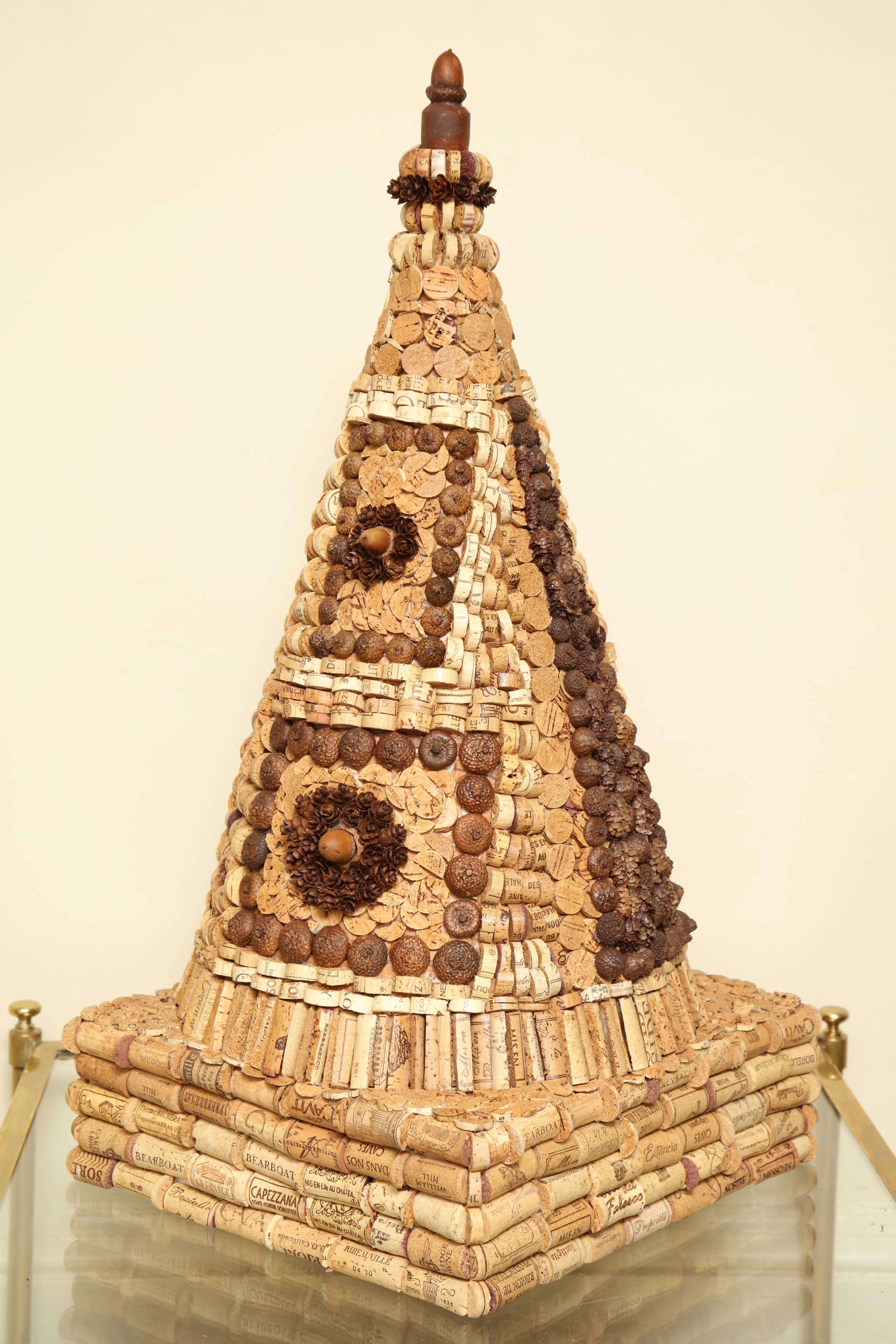 With a nod to Tramp Art, McEvoy takes spliced wine bottle corks, pinecones, and acorns to build out her architectural creations in her signature color palette of natural, white, black and red. 

Marian McEvoy lived in Paris from 1975-1990, where