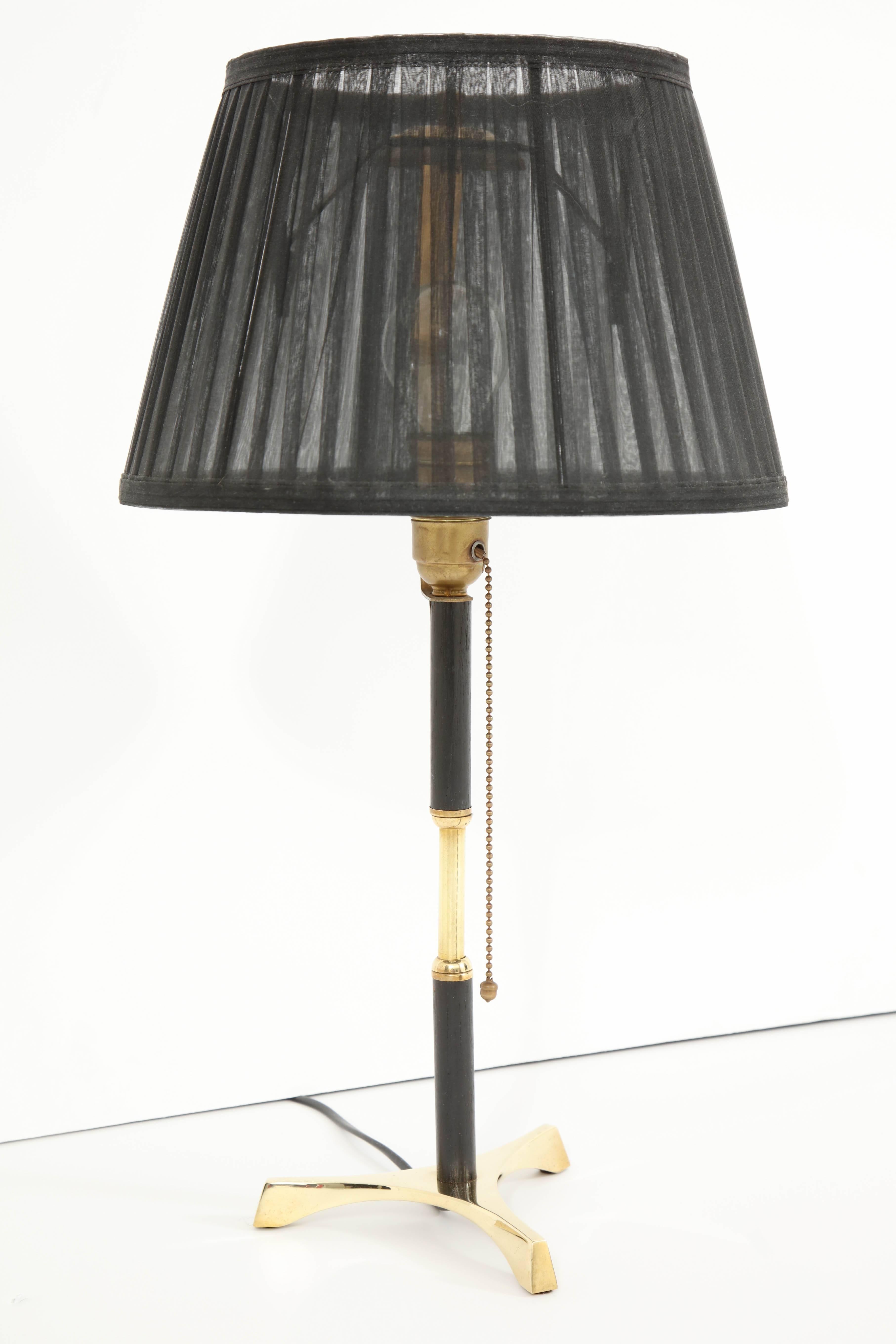 Decorative mid-century modern table lamp, circa 1960, Italy. Polished brass with black palm wood details. Black lampshade.