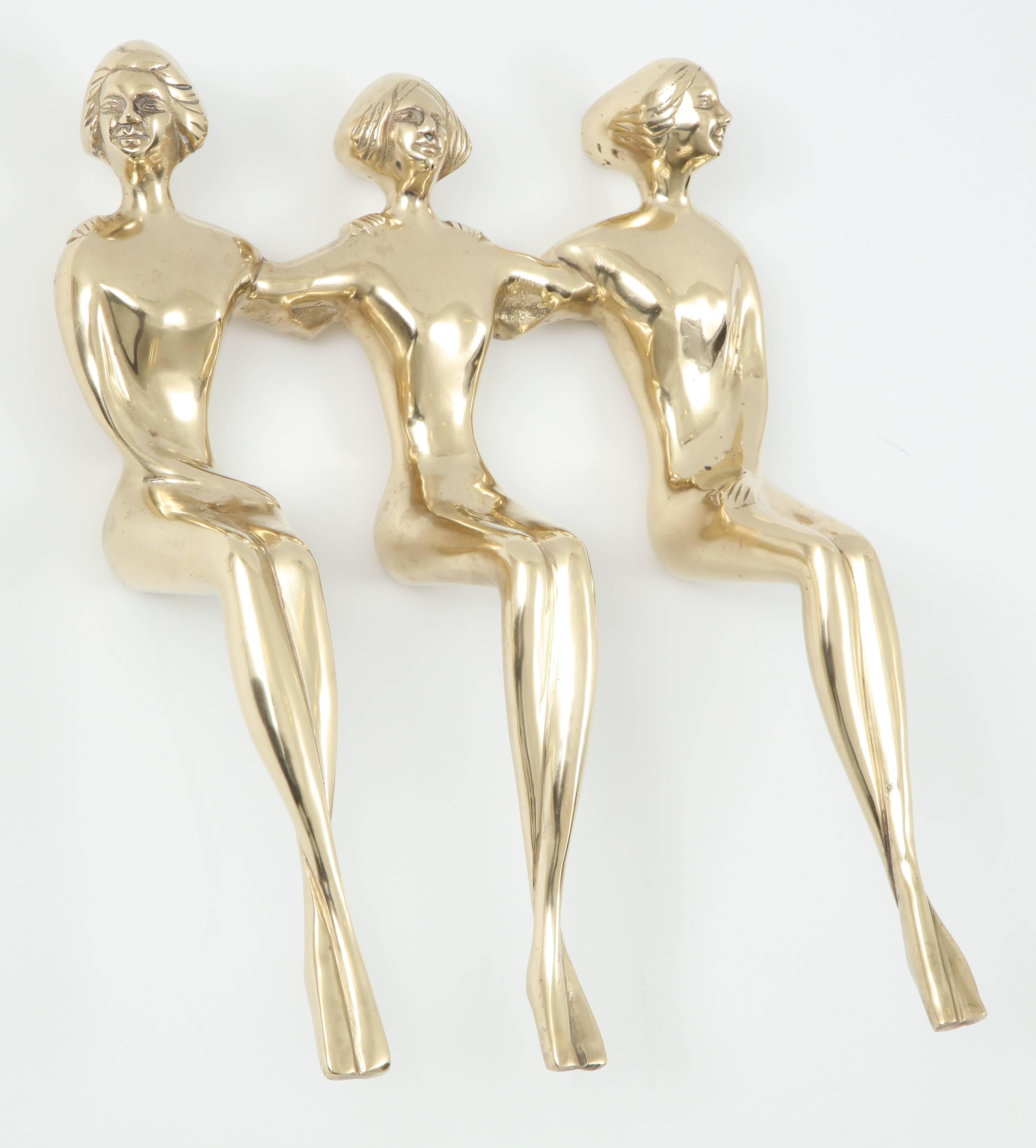 Mid-Century polished brass sculpture of three ladies sitting together, circa 1950.