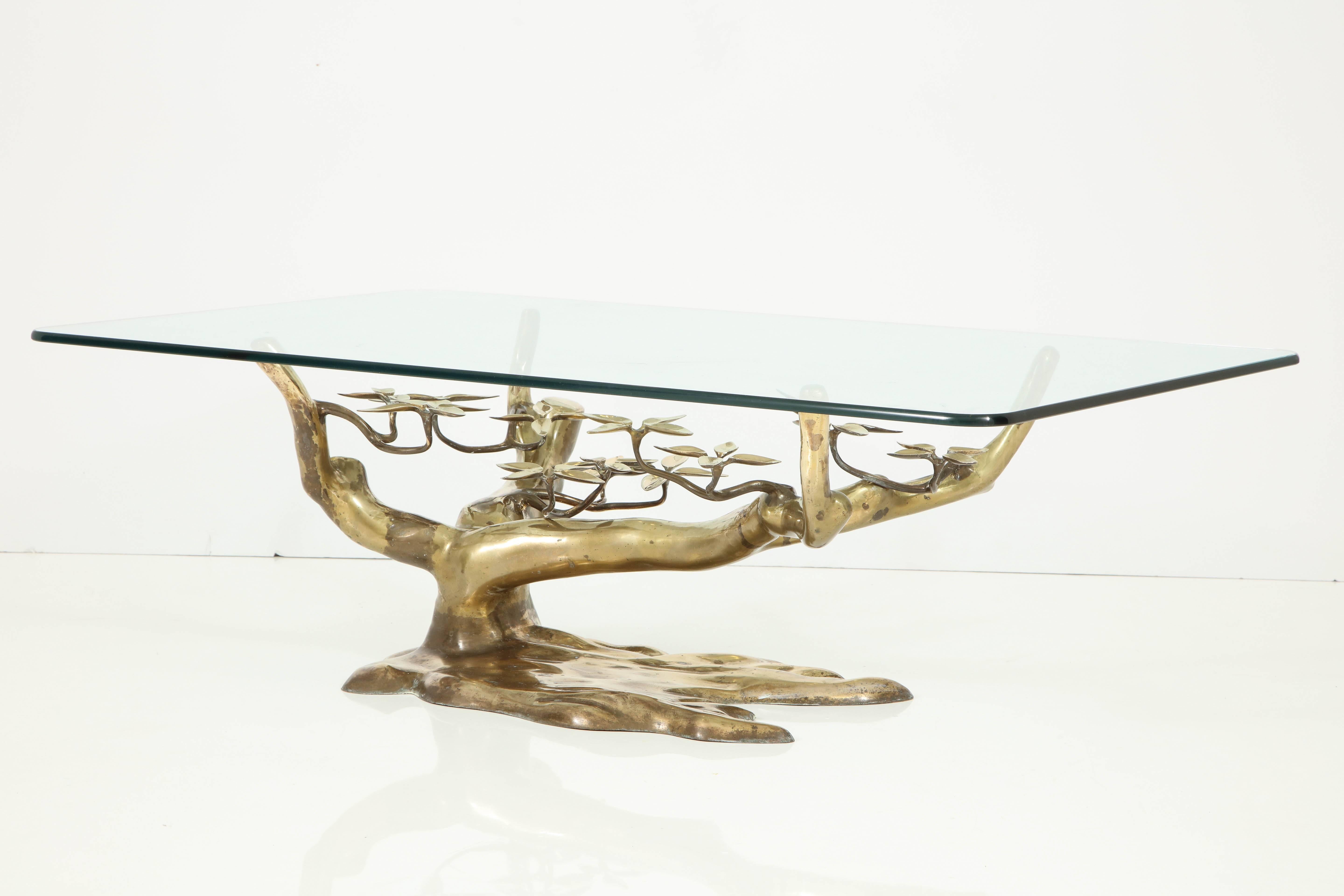 This piece is a show stopper! Attributed to Belgian designer Willy Daro, the table features a sculptural brass base with branches and leaves, under a large glass top. The table is a work of art, and is pretty to look at from all angles.