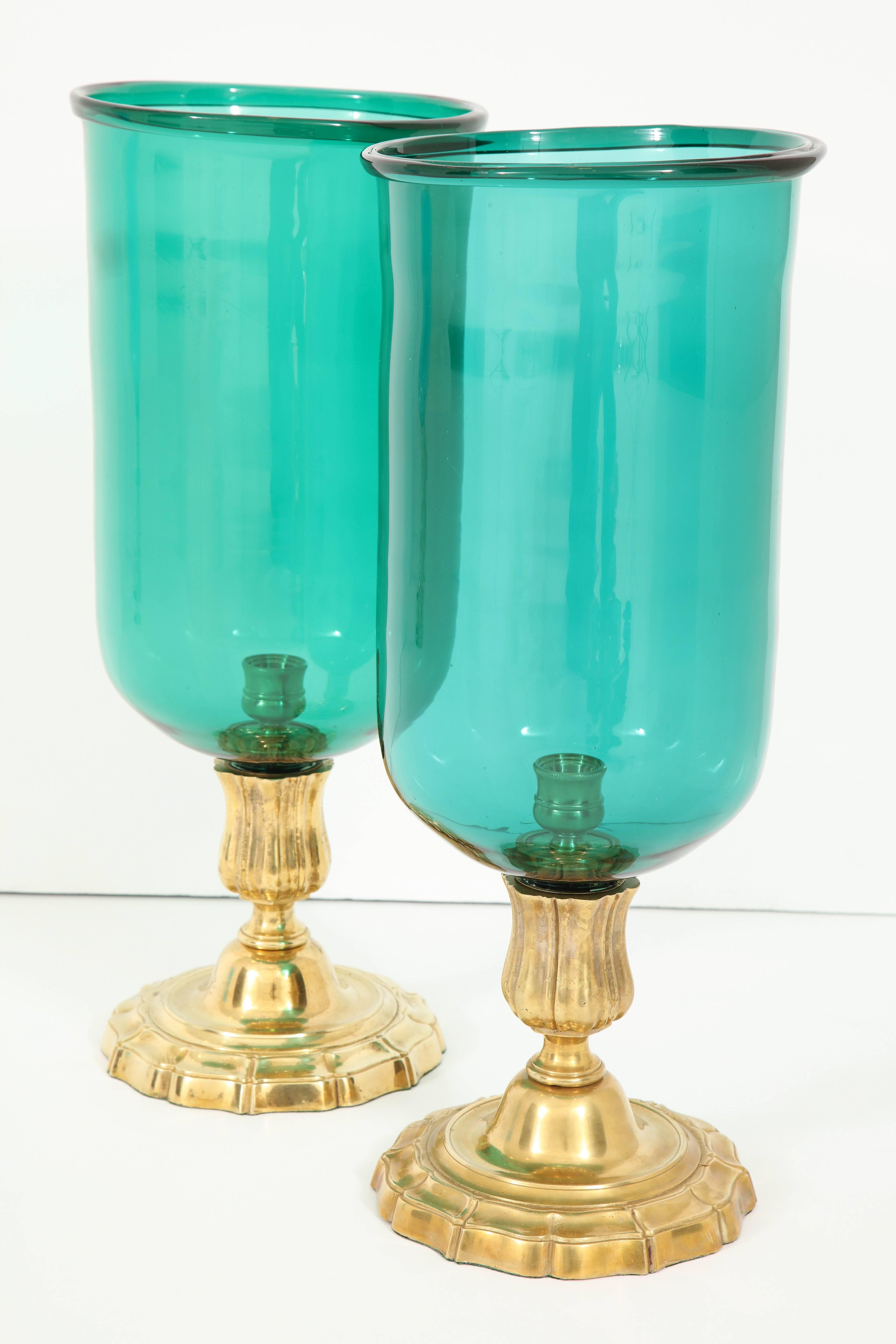 A pair of blown glass hurricane lamps in a stunning emerald green on a gilt bronze base.  