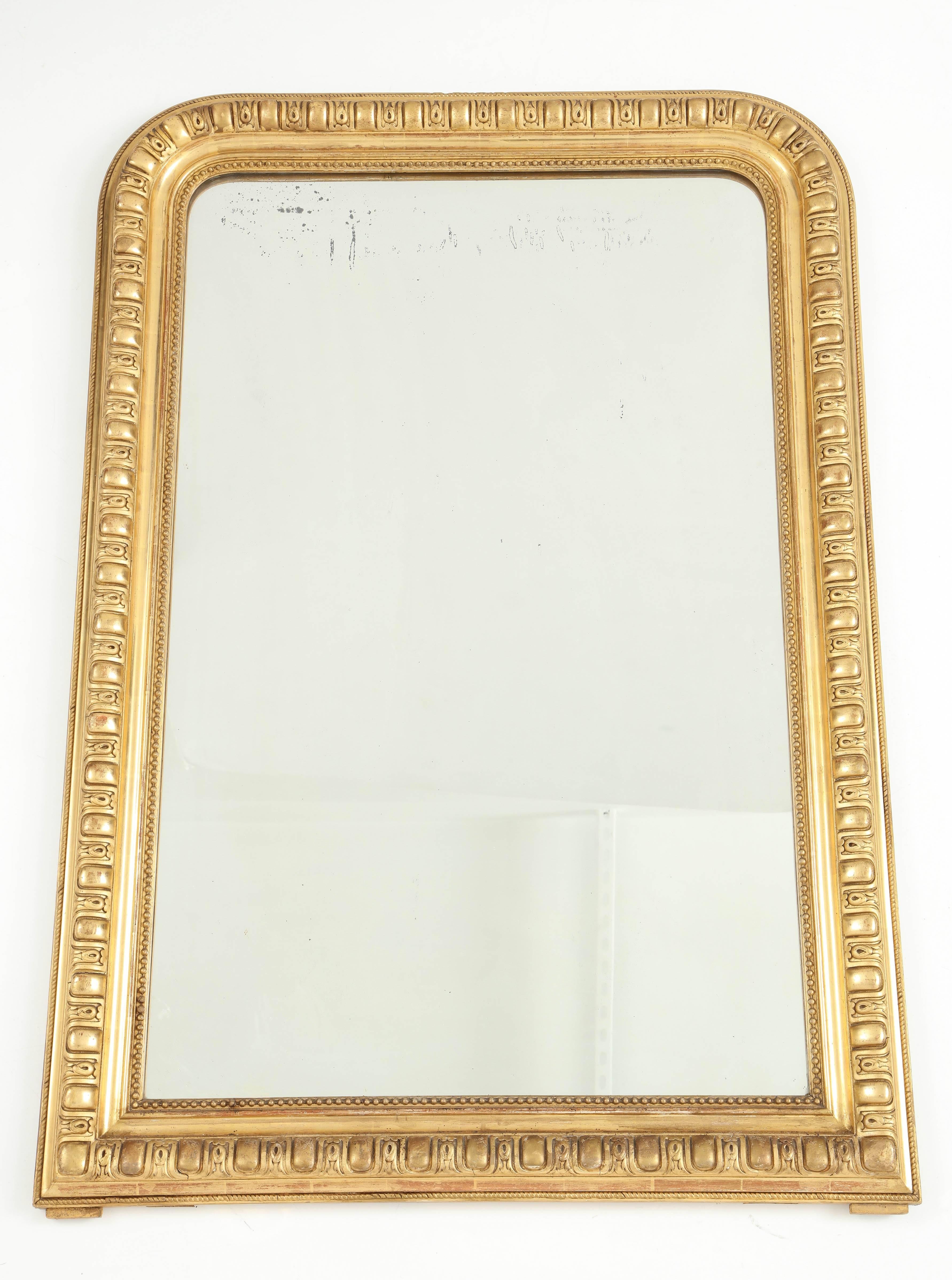 This Louis Philippe giltwood mirror has unusual and carved detail in its giltwood frame and an inner beaded molding. The clean lines of this special piece allow it to decorate contemporary as well as traditional spaces.