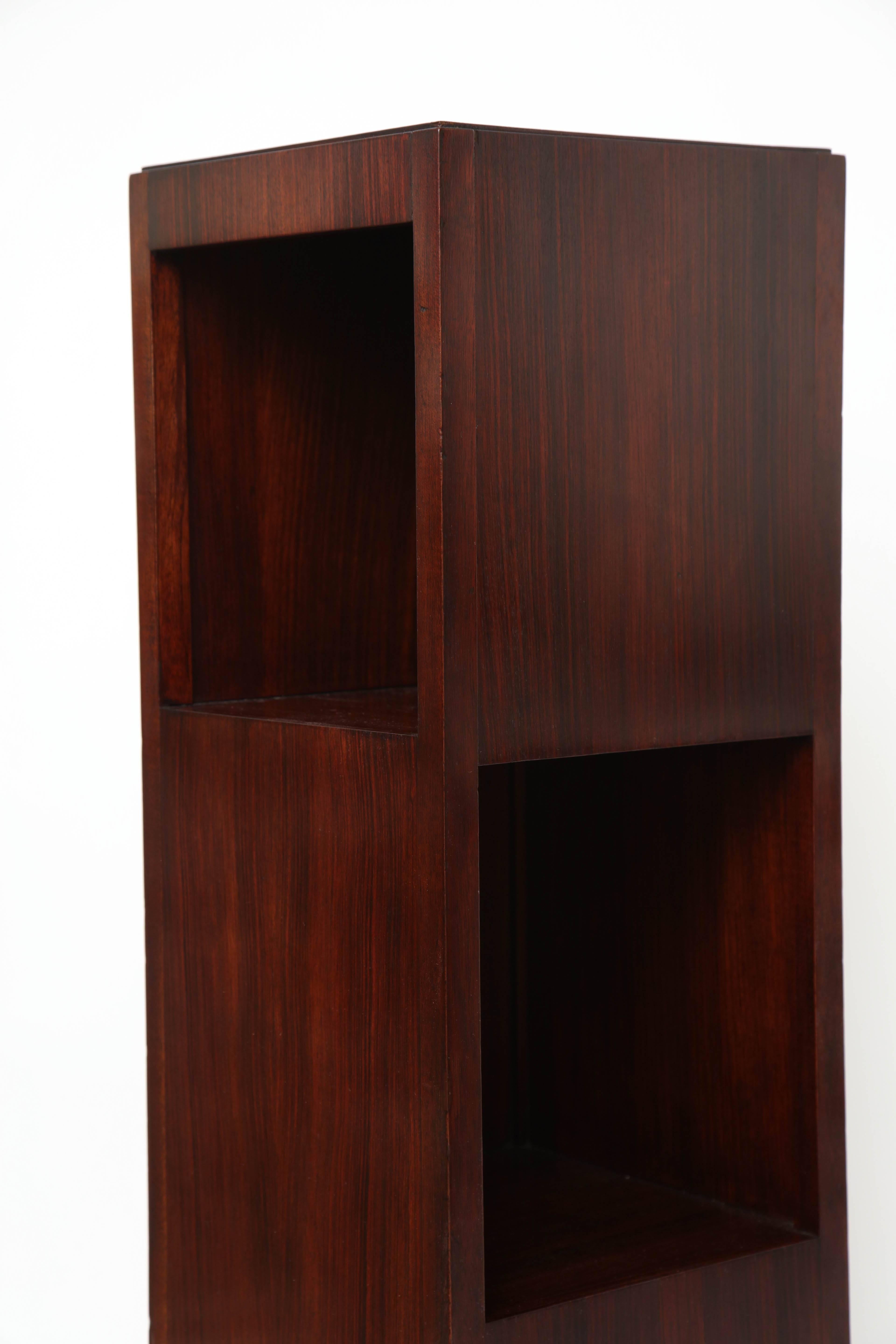Unusual French Art Deco rosewood pedestal bookcase. Two faces with offset openings.