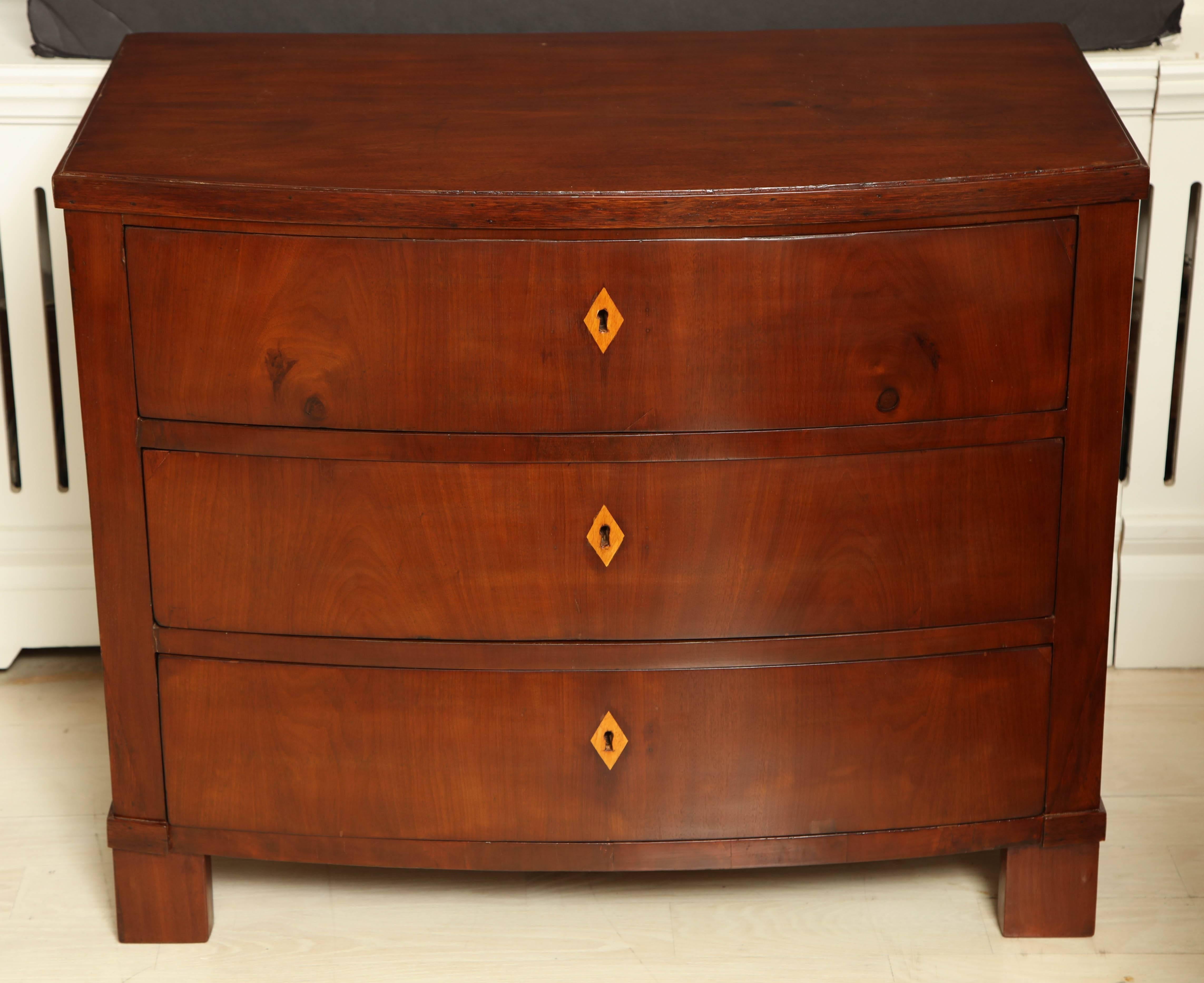 Three-drawer bow front mahogany Biedermeier style commode with inlaid satinwood escutcheons, Italy, circa 1830.