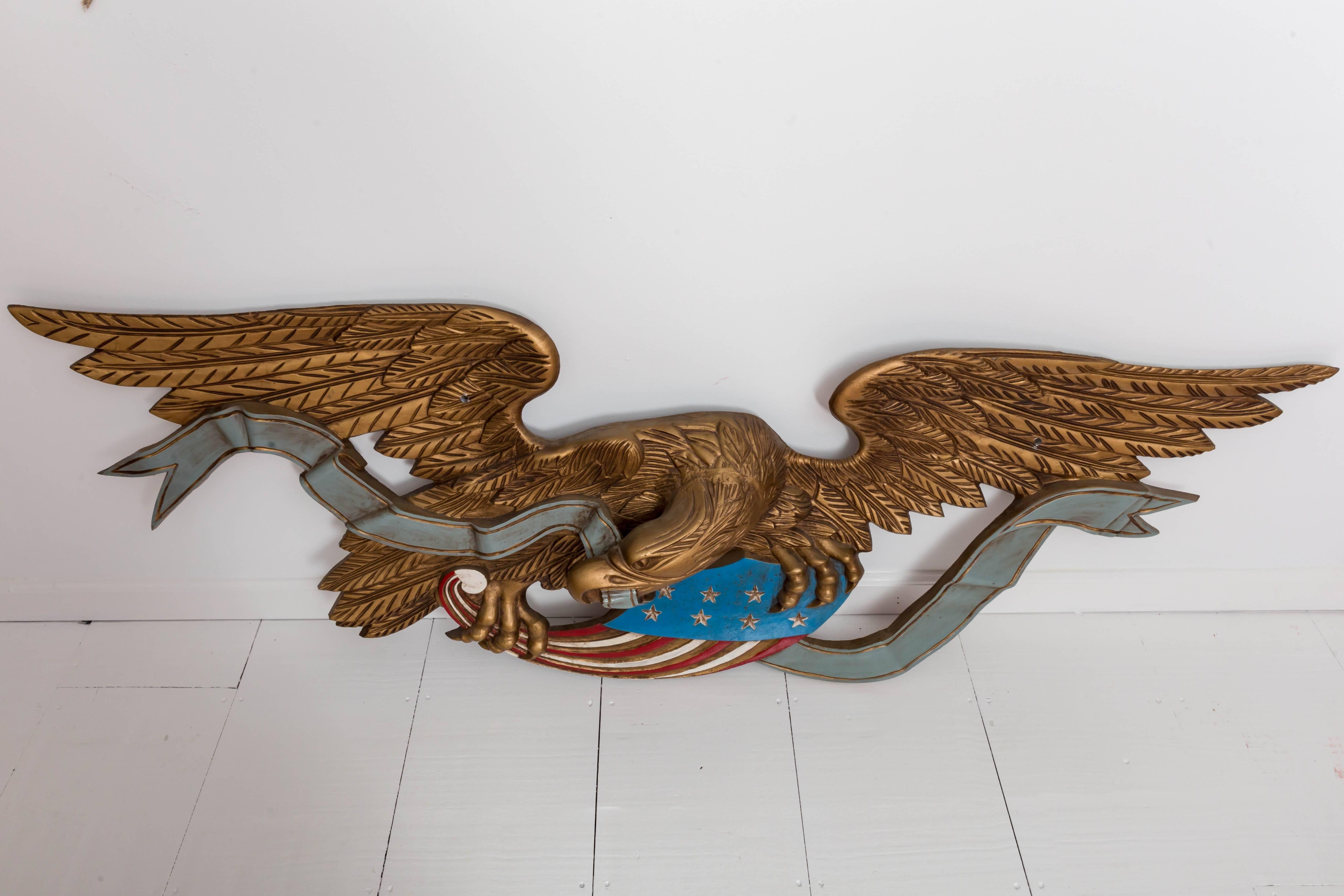 Over-scale 6 ft paint decorated cast iron Bellamy style American Eagle wall plaque. Holding an American flag and banner. Came from a Southampton, NY Estate.
