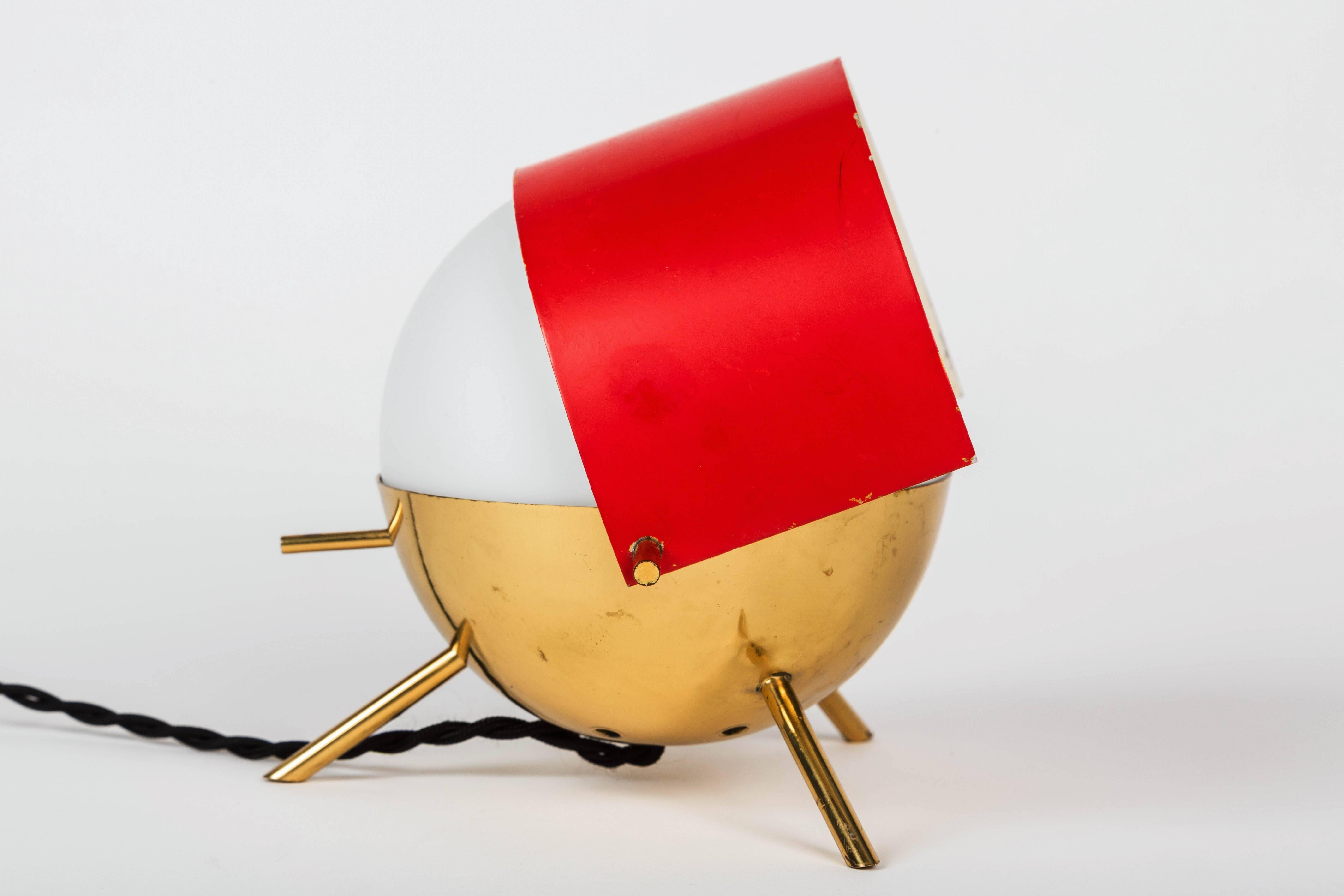 1950s Stilux Milano Tripod 'Visor' table lamp. This whimsical and sculptural lamp is executed in opaline glass, lightly patinated brass and painted metal adjustable visor with original red color in very good vintage condition.

Stilux was one of