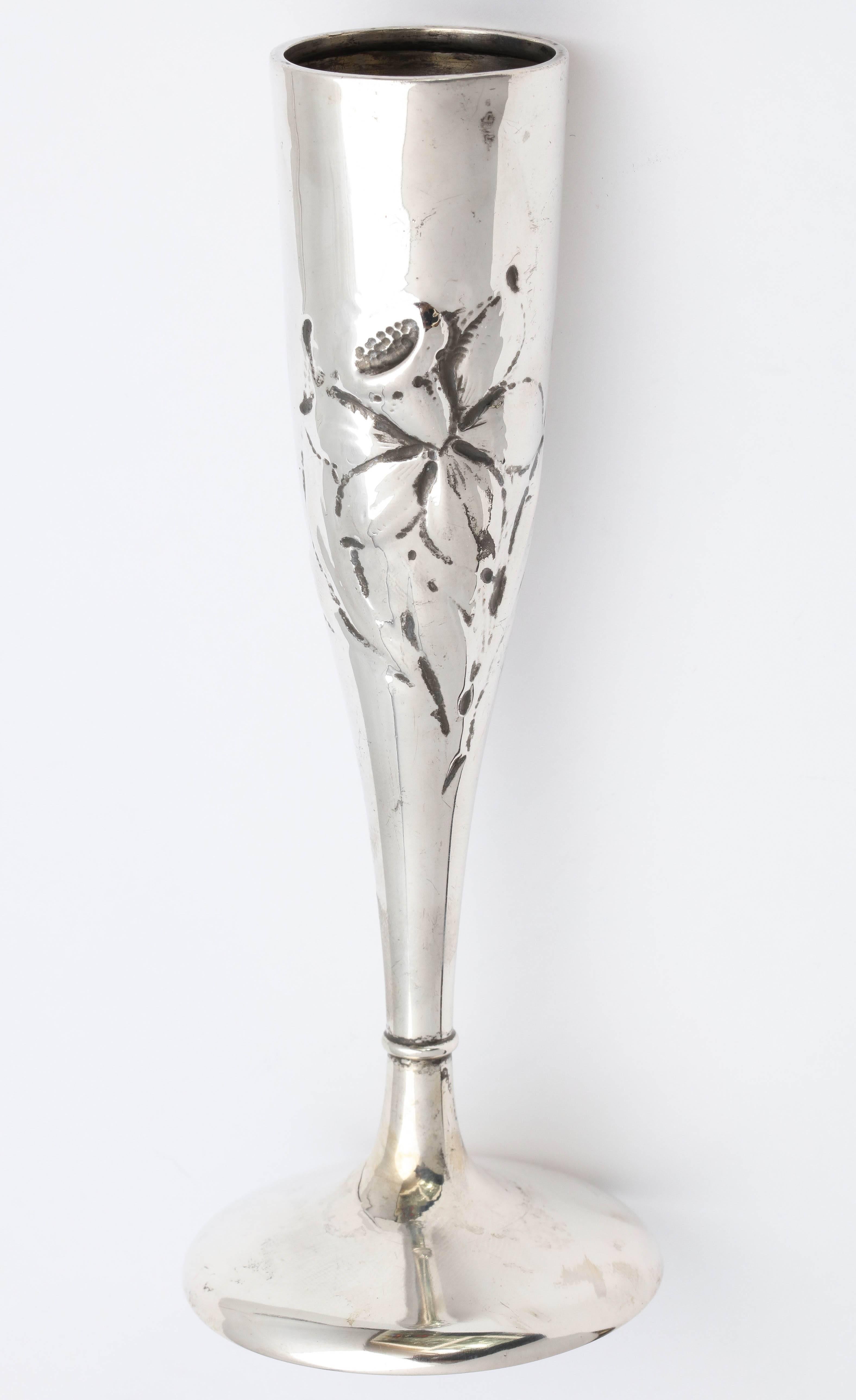 Art Nouveau, sterling silver bud vase, American, circa 1895-1905. Decorated with a single lily which wraps itself around the vase. Measures: 6 1/2 inches high x 1 1/2 inches diameter across opening x 2 1/2 inches diameter across base. Weighs 1.930