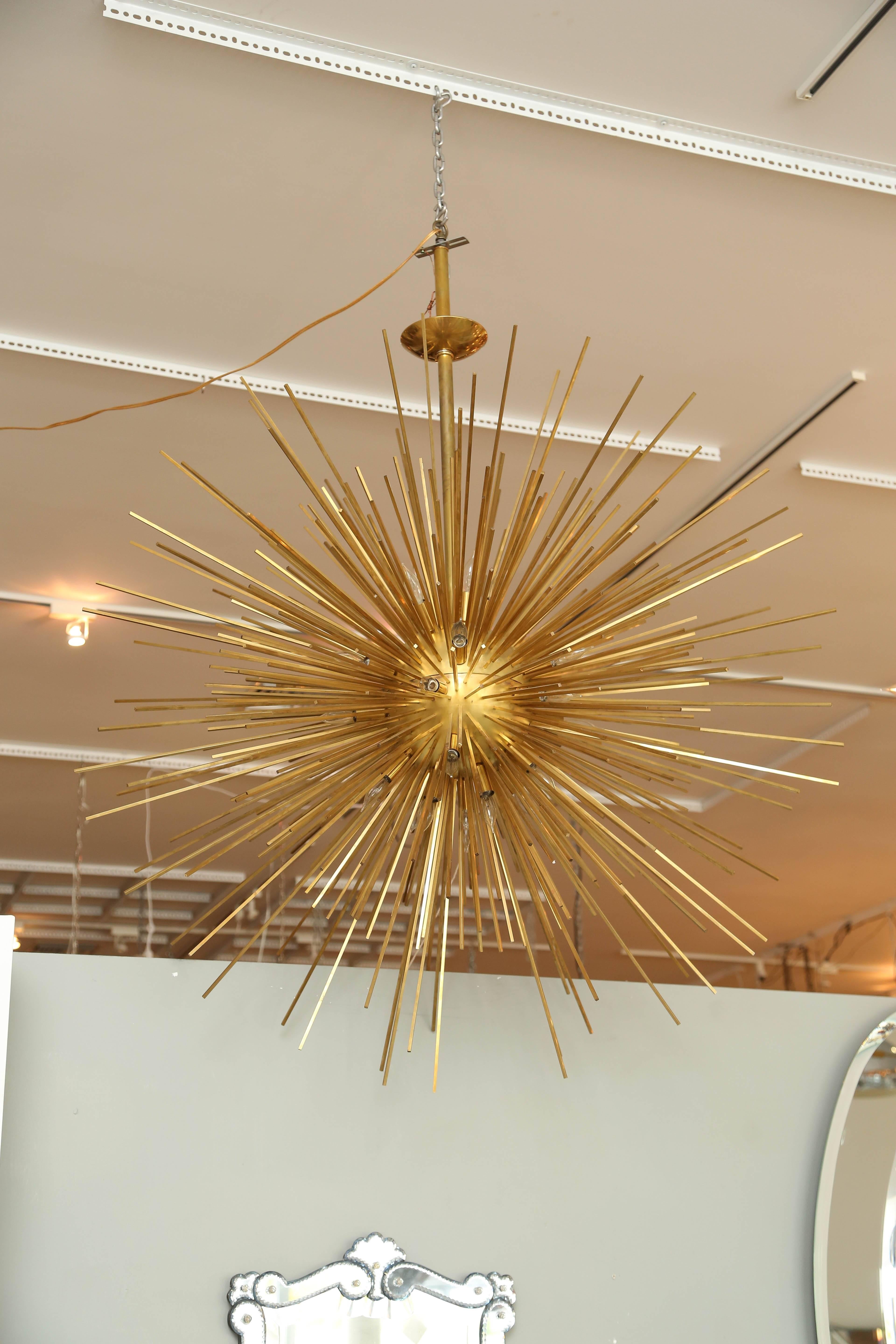Monumental brass sputnik light fixture with 28 sockets. The design involves a very dense array of spokes of varying lengths. 

