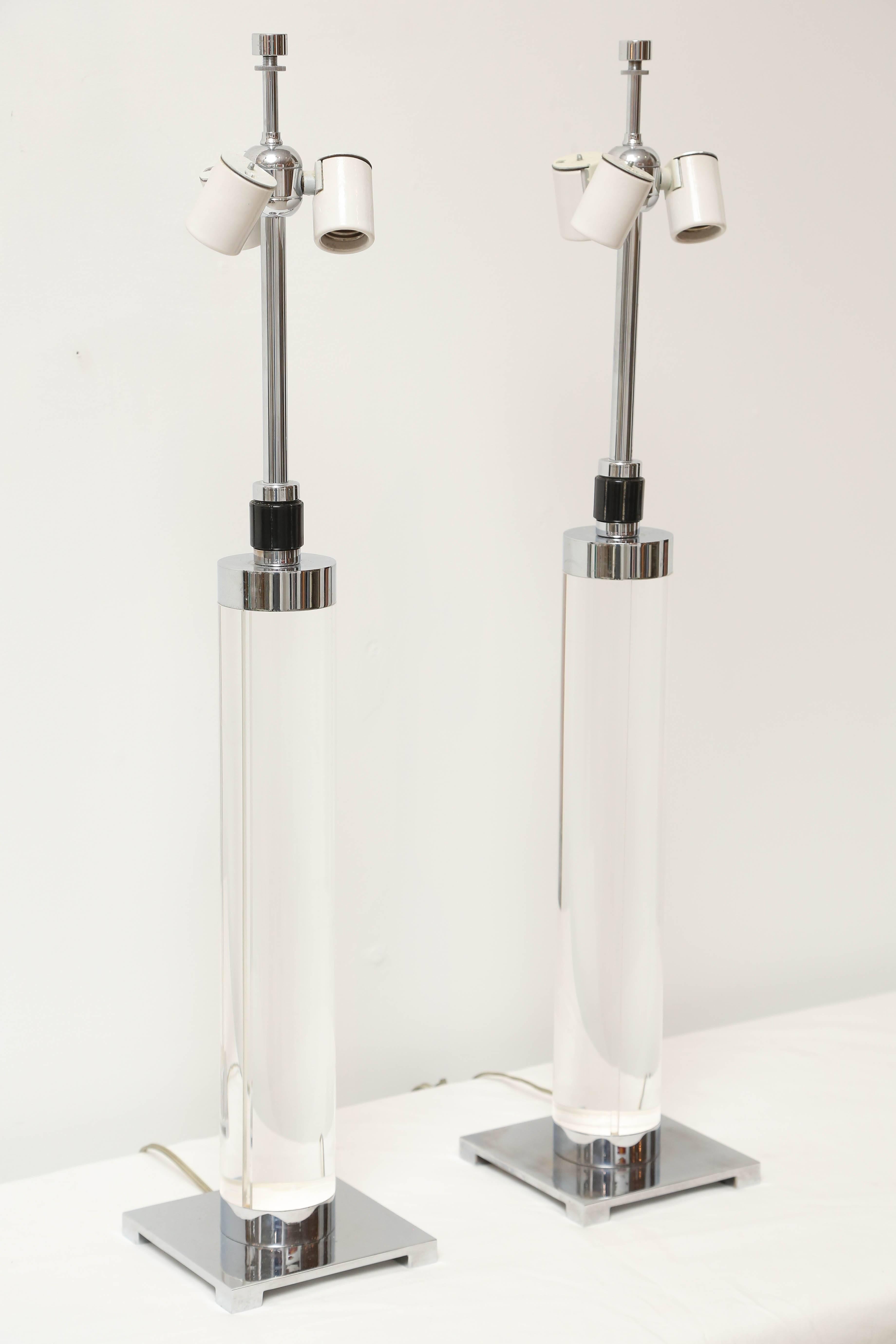 Pair of cylindrical Lucite and chrome table lamps with hidden cord in channel at back of lamp.
Original hardware.