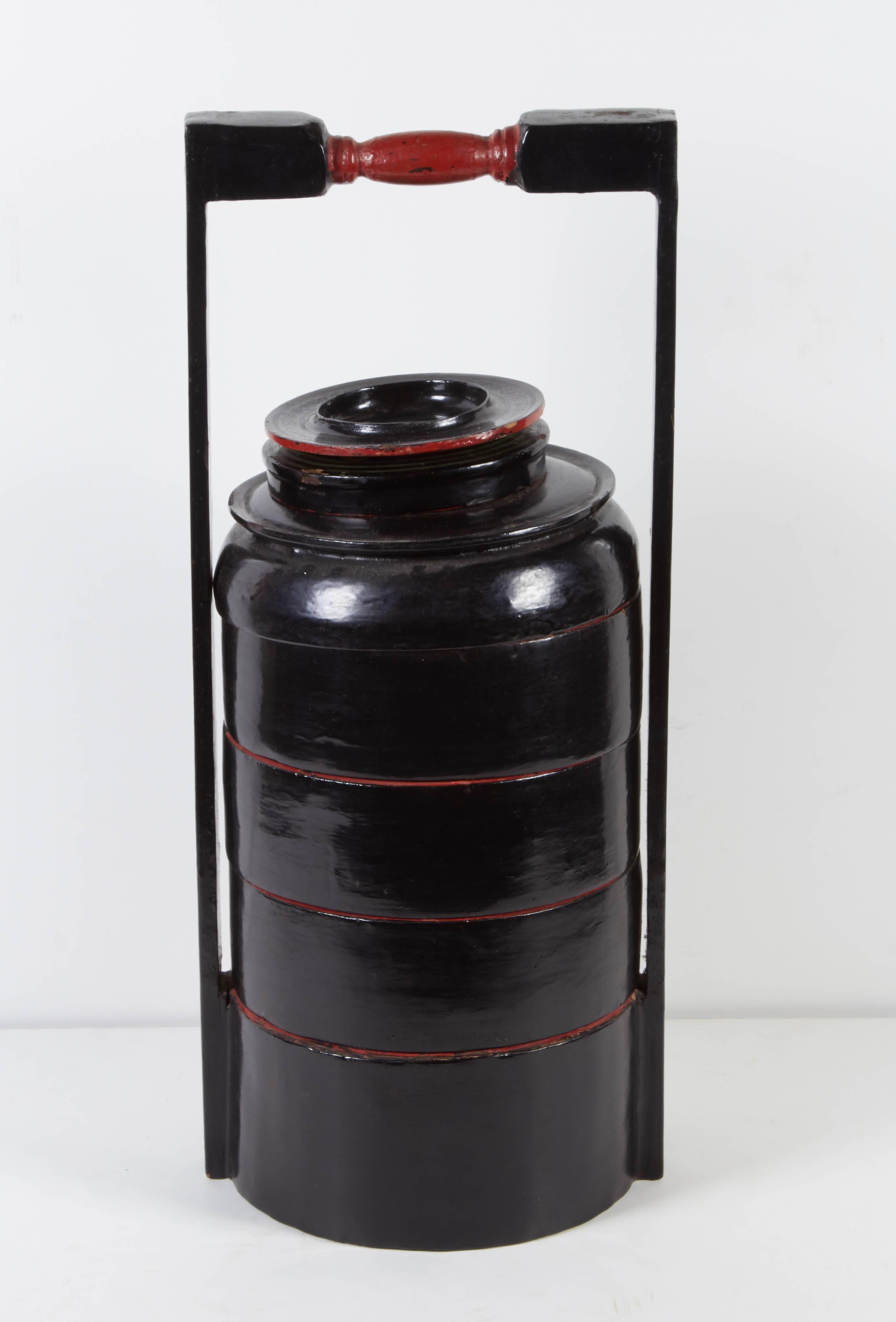 A beautifully lacquered vintage Burmese multilayered food container with five separate compartments. The vibrant red interior complements the elegant form of the black lacquer exterior. See additional images for interior.

L328.