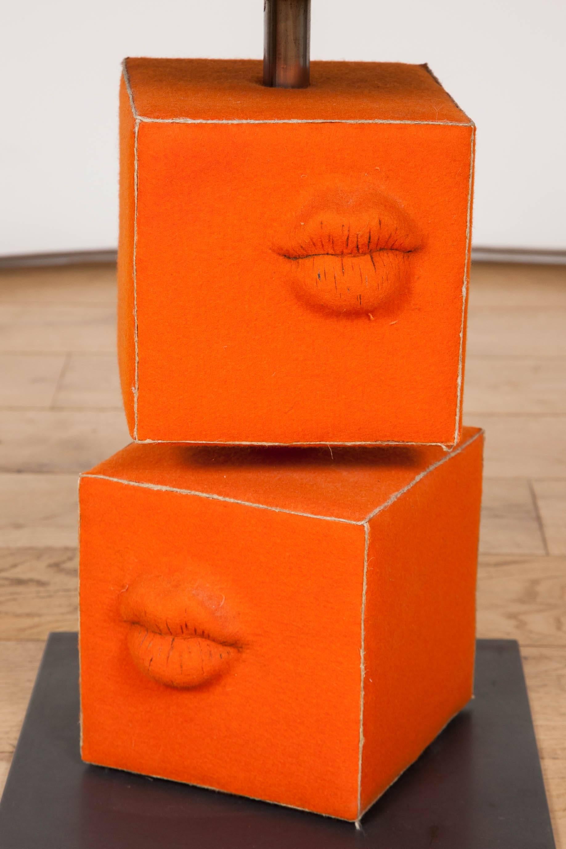 Contemporary, French 
An imaginative and witty design, the stool has 2 stacked, orange felt 'cubes' with lips emerging in relief topped with a patinated metal seat.
Both felt cubes can be pivoted independent of the other on the shaft.