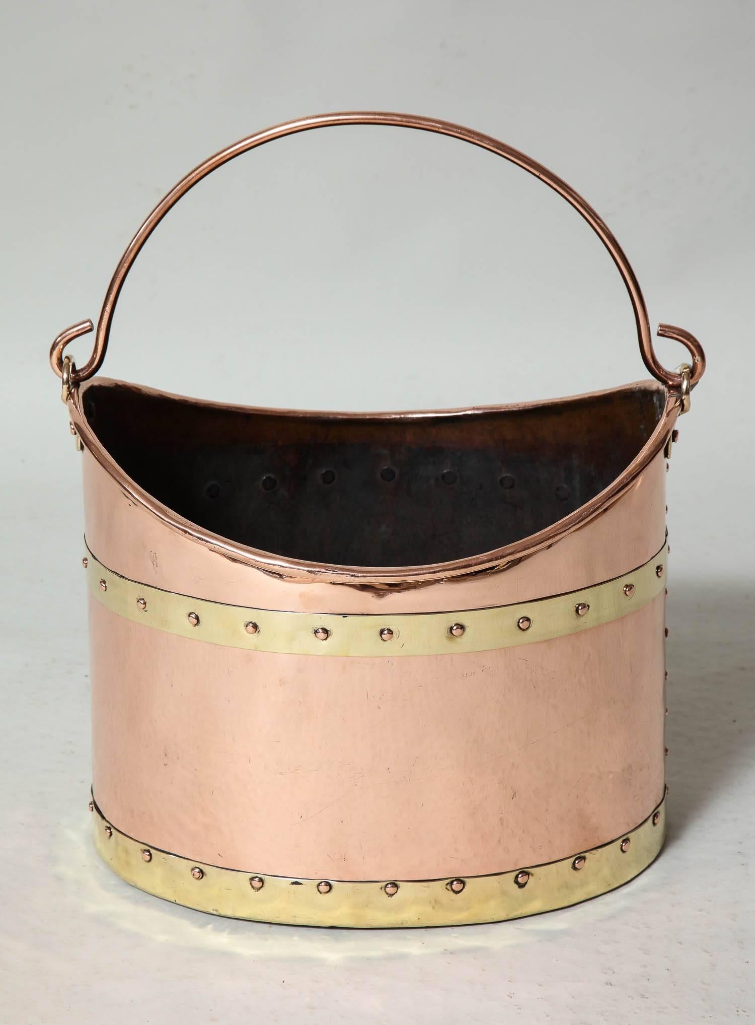 Fine English 19th century brass bound copper bucket having a bail handle, rolled lip, brass bands with studded copper riveted seams, the whole with well polished surface and of skilled craftsmanship.