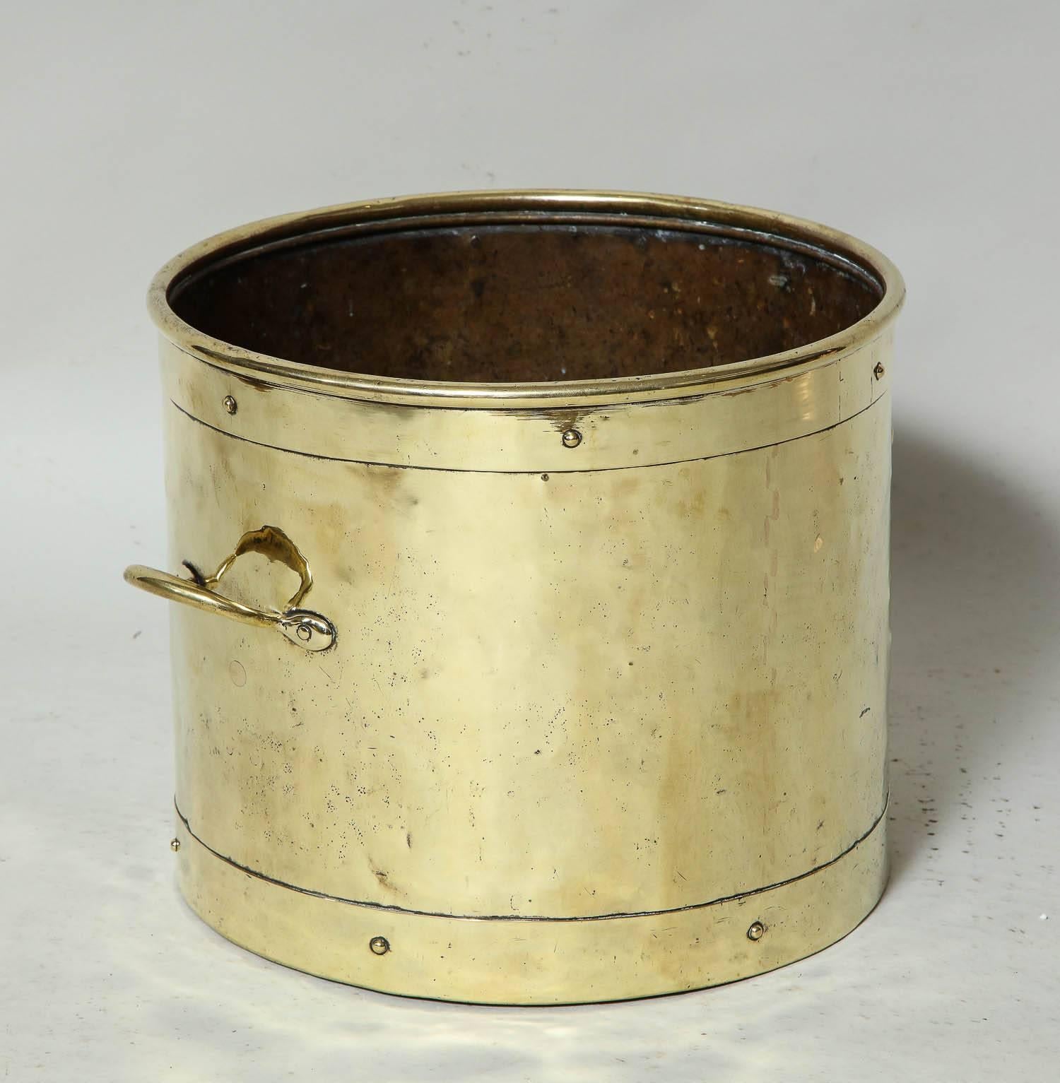 Good 19th century English kindling bin in brass with rolled rim and brass riveted bands, and two brass carrying handles.  Useful next to a fireplace for kindling.
