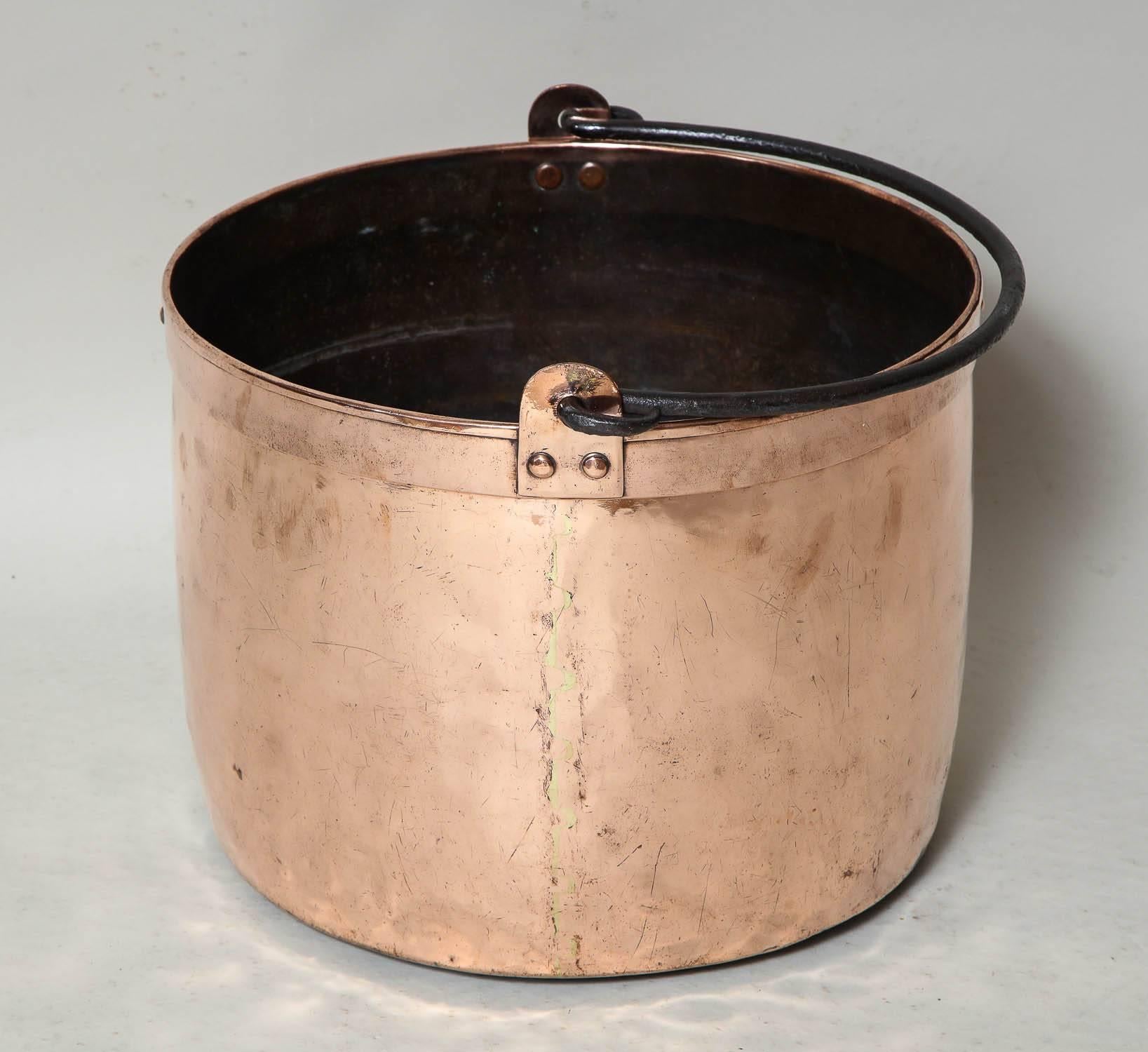 Good 19th century copper pot with rolled lip, wrought iron handle, the dovetailed seam having brass solder, the whole with great scale and ideal size for firewood.