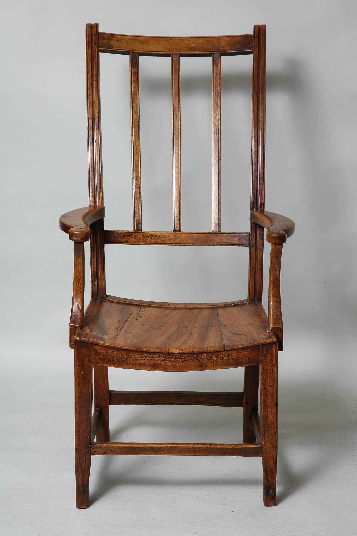 A good early 19th century East Anglian tall chair in nicely patinated fruitwood and elm with swept back and shaped arms, the curved seat over square tapered legs with box stretchers.