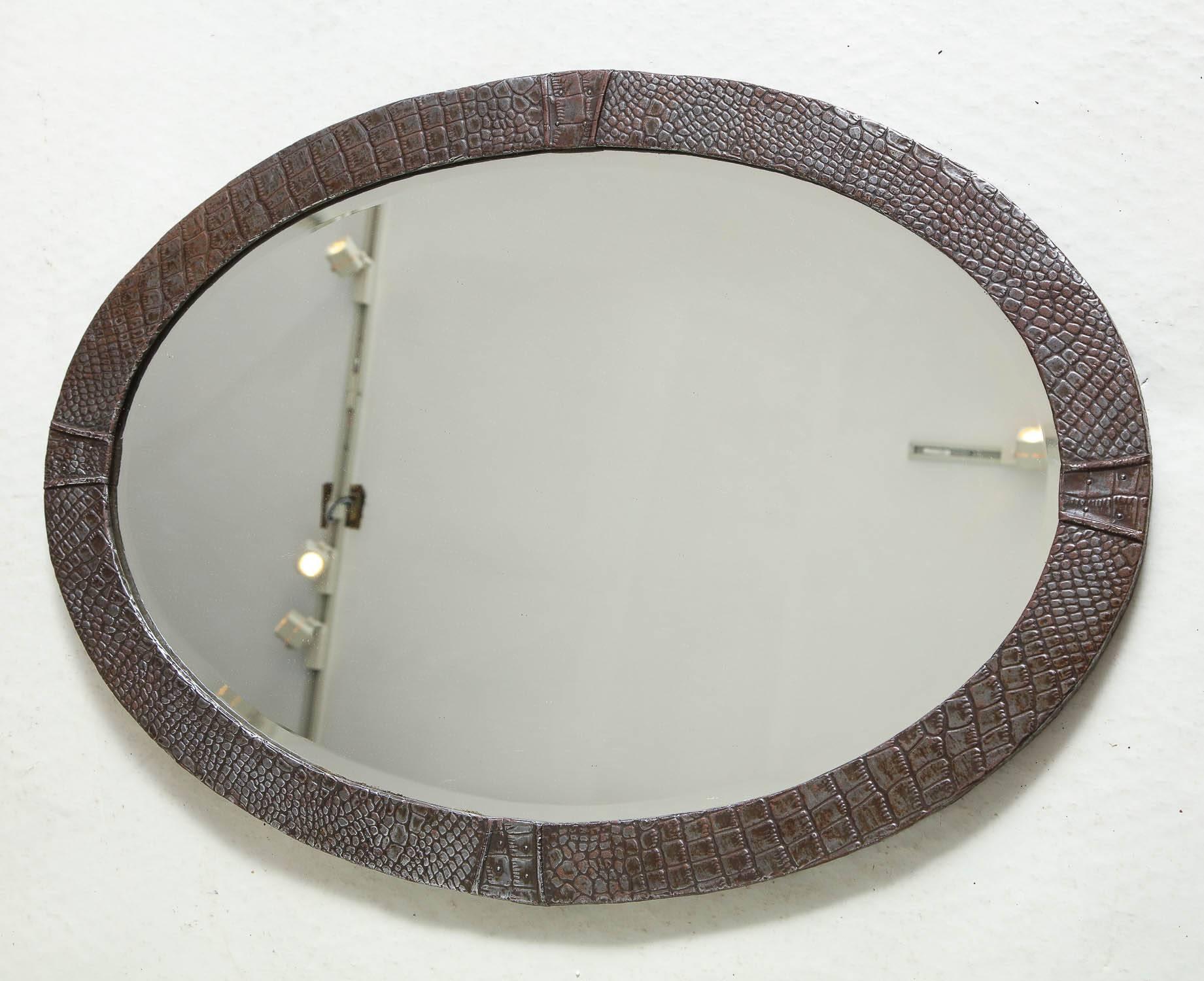 Good English Arts and Crafts period oval mirror in patinated steel and hand-hammered in 