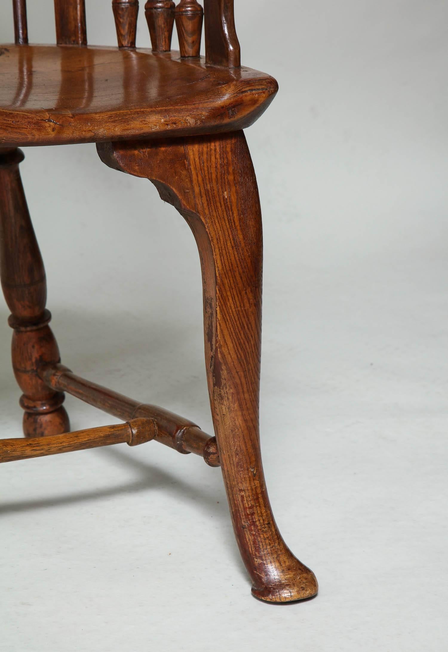 L'un des plus beaux fauteuils à dossier peigne de style Windsor du XVIIIe siècle que l'on puisse trouver sur le marché, cet exemplaire présente une traverse festonnée et façonnée au-dessus d'un dosseret percé de tracés gothiques, des traverses