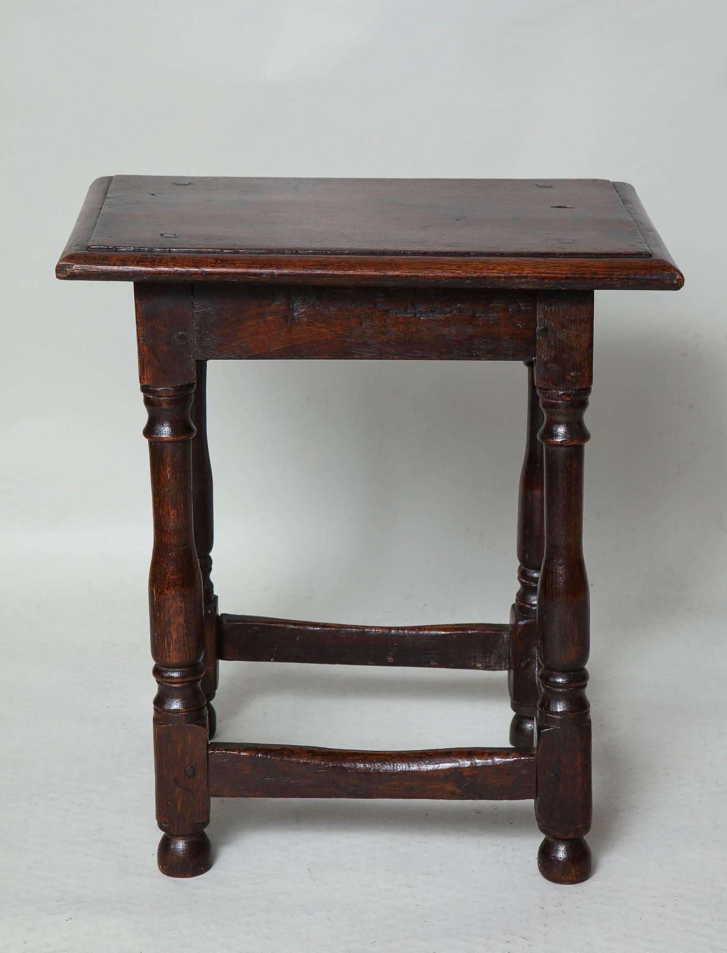 Good 19th century English oak centre table/joint stool with thumb molded top over balustrade turned legs joined by box stretchers and standing on original bun feet.
 