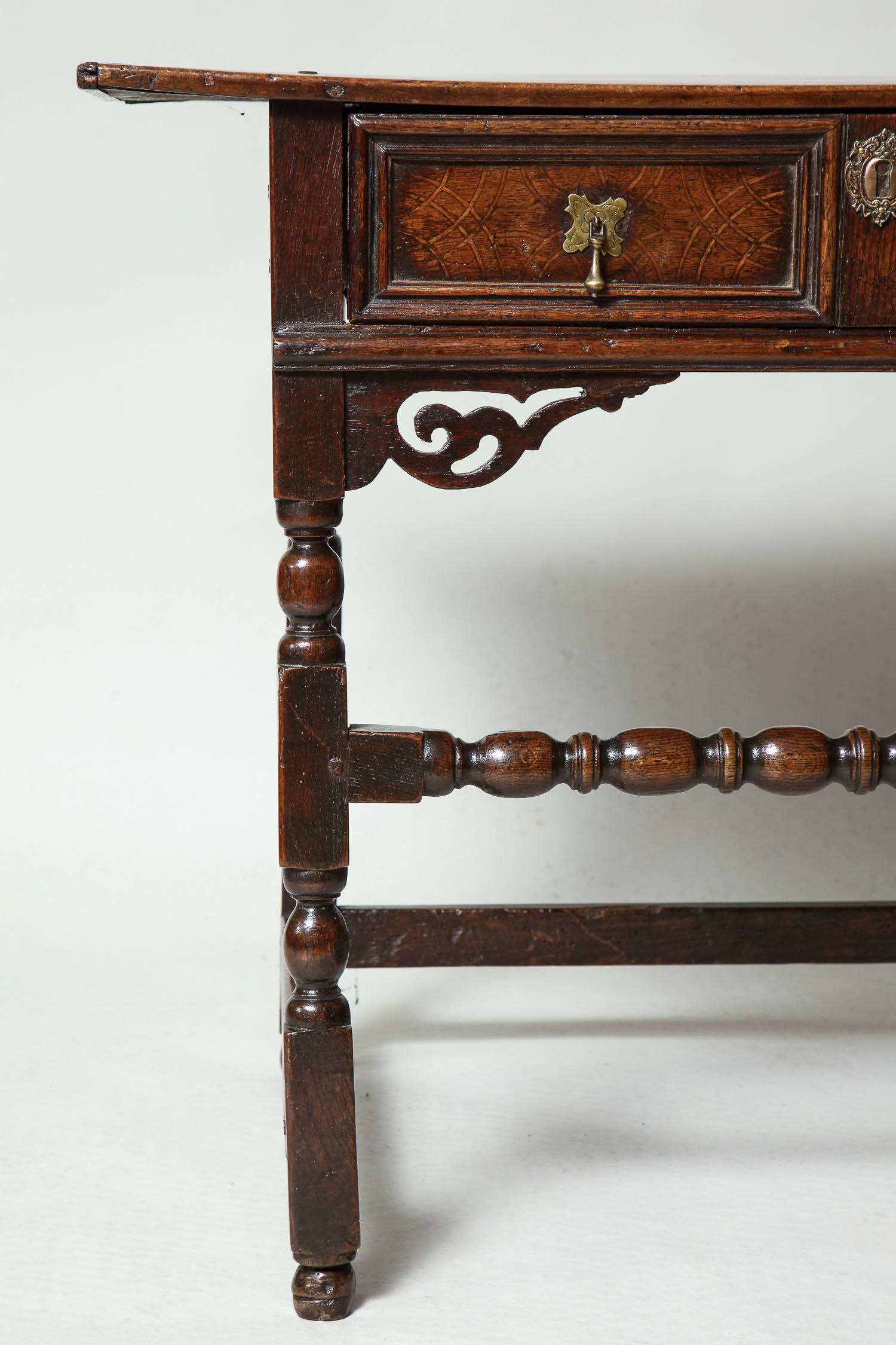 Fine Charles II period side table, the two plank top with breadboard ends, over geometric molded single drawer with inlaid semicircle panels over well-turned legs having pierced and scrolled spandrels and joined by high turned stretcher, the whole