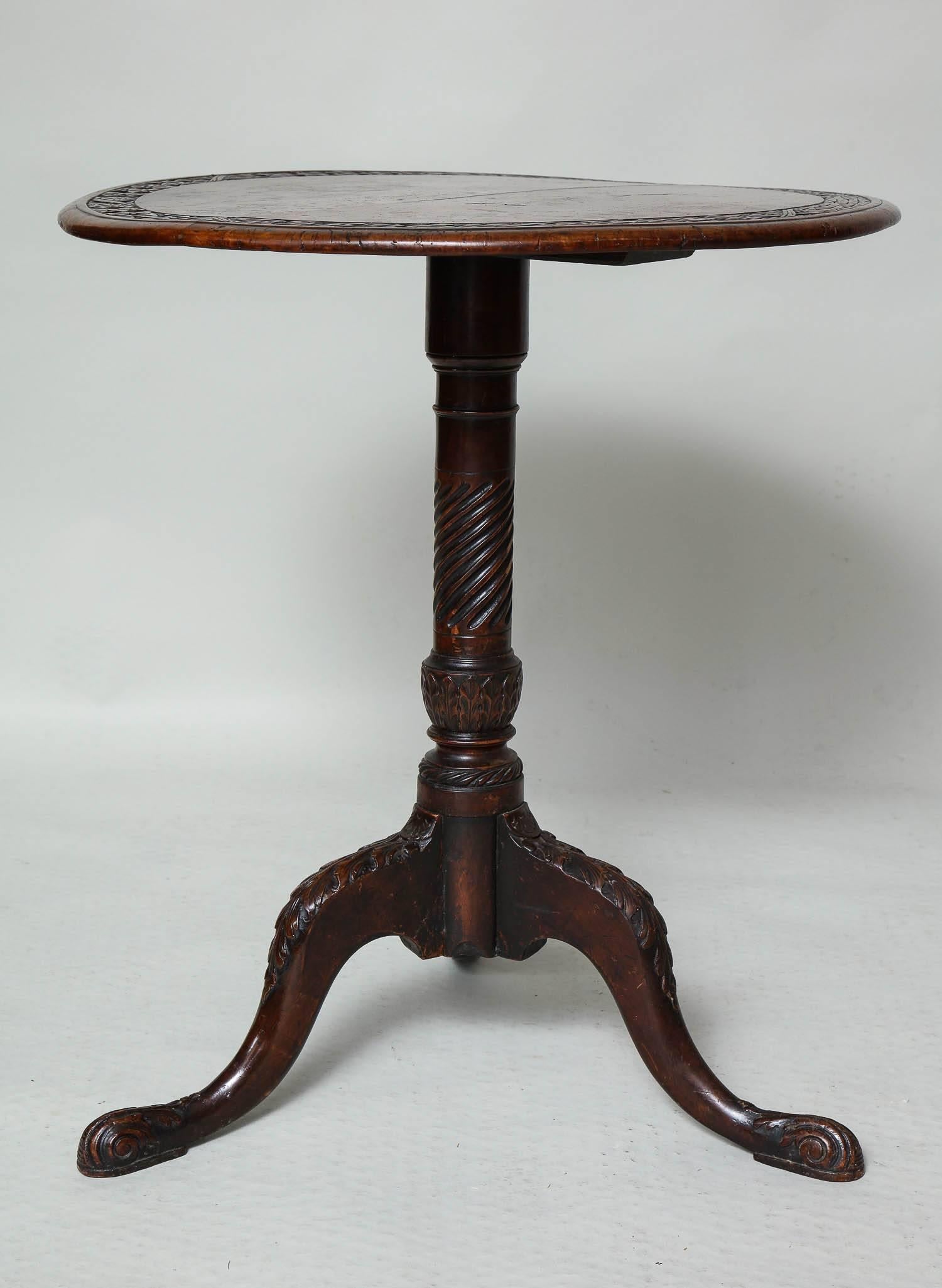 Most unusual Irish tripod table, the top constructed of two planks of solid burl timber and having a carved wreath band over spiral fluted and acanthus leaf carved shaft, the foliate carved legs ending in carved scroll legs, the whole possessing