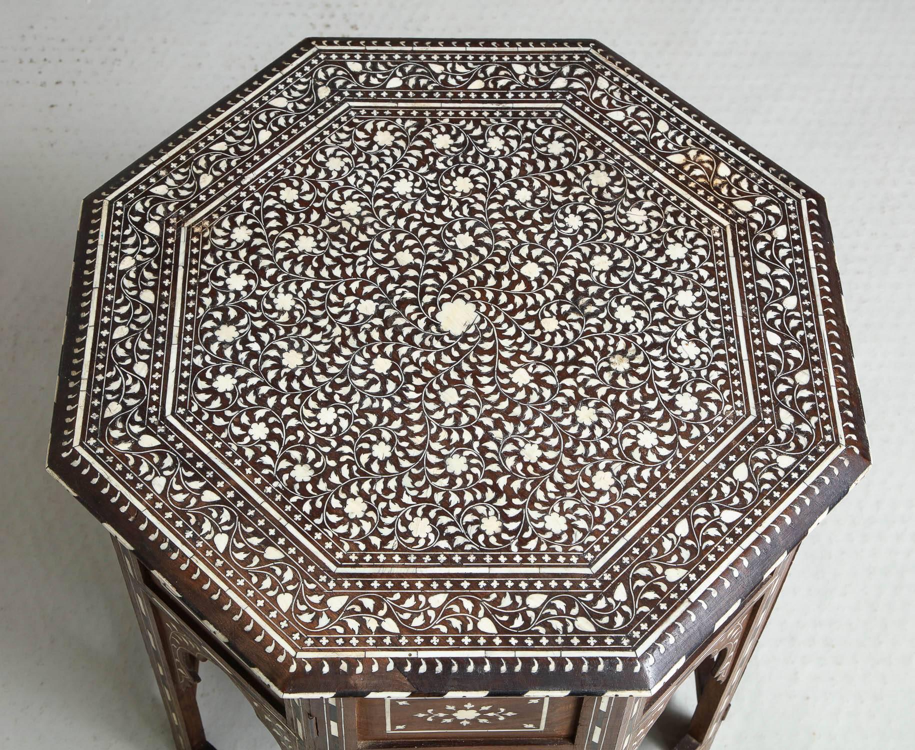 Very fine 19th Century Indian sandalwood table profusely inlaid with bone and floral decoration, standing on accordion hinged base with bone and ebony inlay, the whole with rich color and patination and in remarkably intact condition.