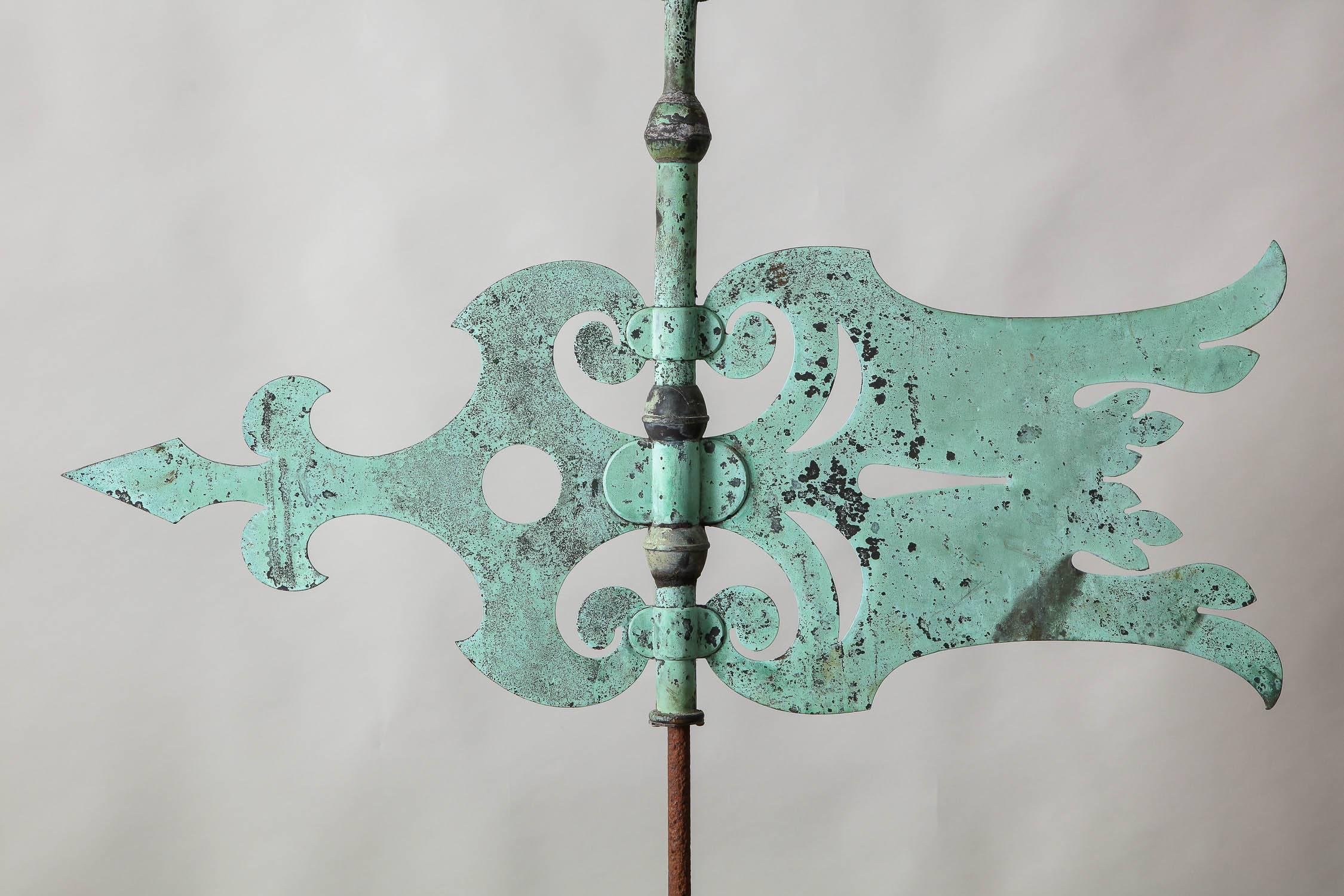 Striking English copper weathervane having exceptional weathered surface in the form of a flying banner with spear finial, fleur-de-lis pointer and pierced decorated body. Great form and imposing scale.