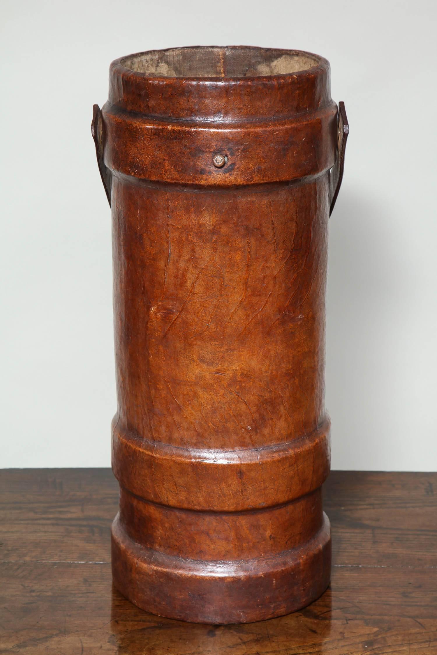 Fine English late 19th century leather cordite carrier, having original carrying handle and the whole with good rich color. Ideal as an umbrella holder or stick stand.

Measures: Height 24