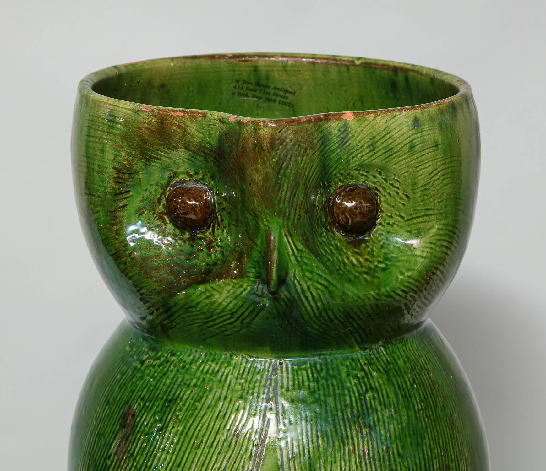 Fine English green glazed earthenware art pottery umbrella or stick stand by Farnham Pottery, having incised feathers and brown glazed eyes and pleasing drippy glazed surface throughout.

Farnham Pottery is best known for much smaller owl jugs;