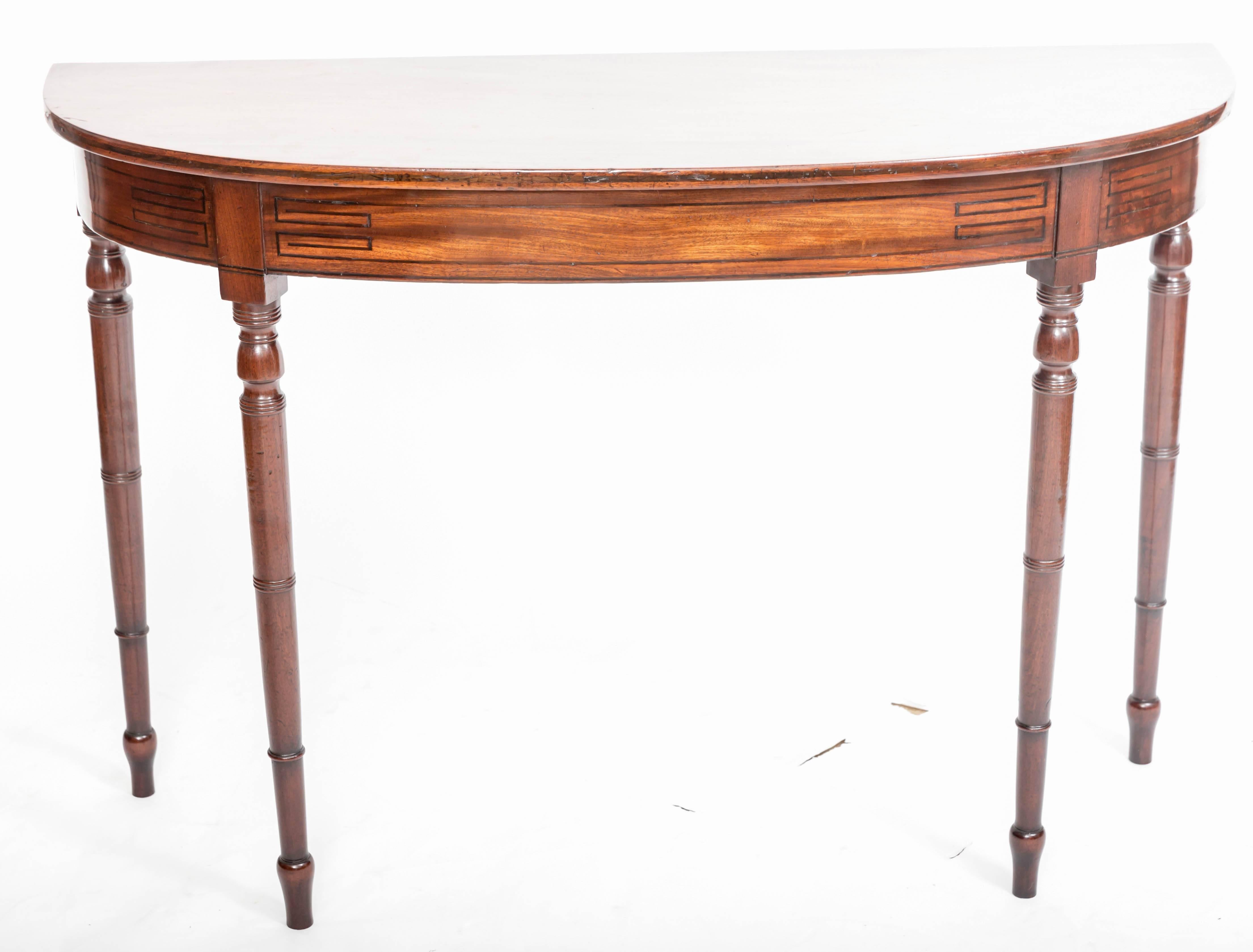 Mahogany demilune table with turned legs and with 3 1/2" apron with
decorative ebony inserts.Measures: 46".