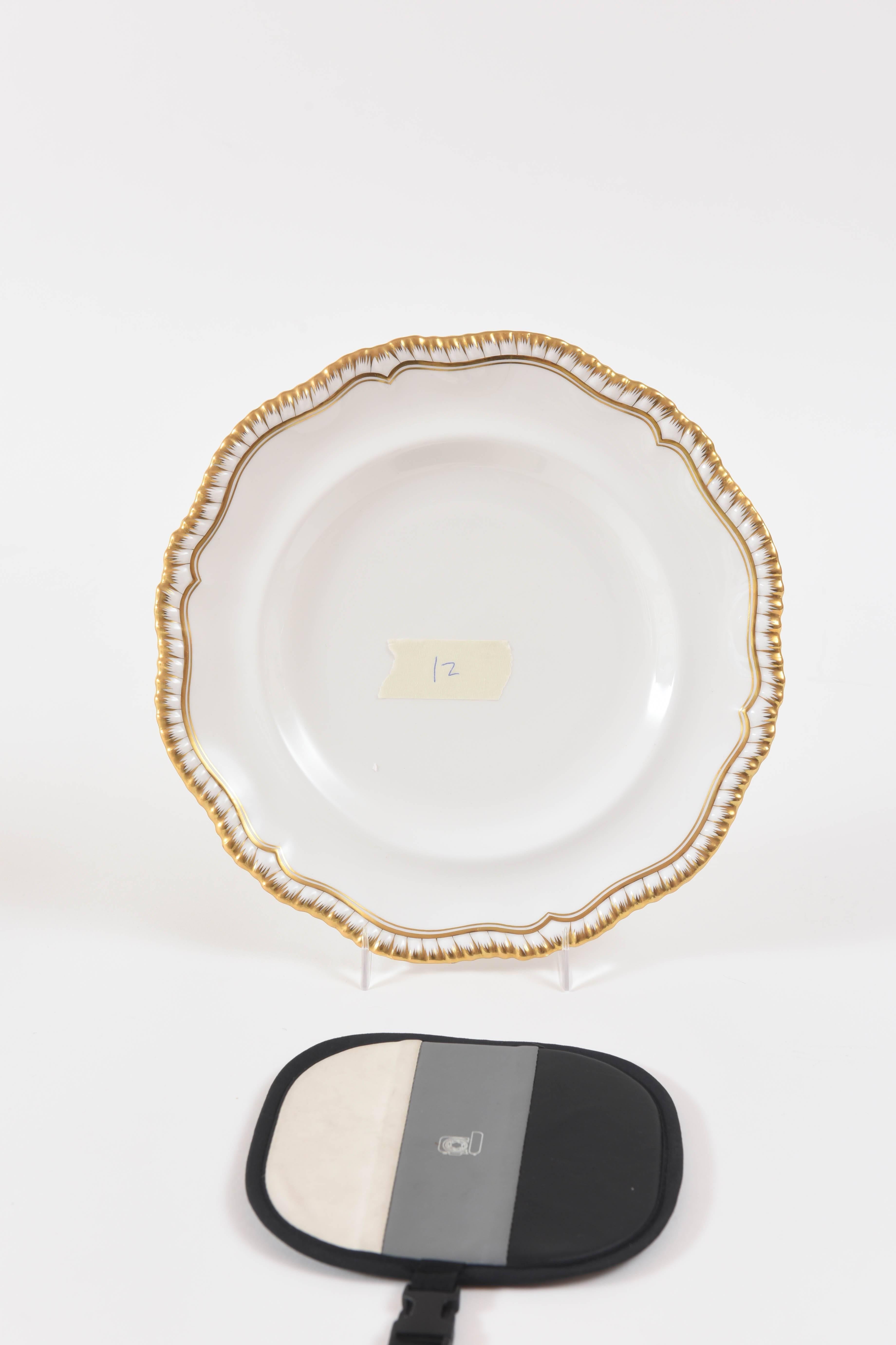 A Classic and elegant set of 12 dinner plates featuring a very pretty shape and hand trimmed gold. Classic and crisp, these will mix and match nicely with all your Fine porcelains. Lovely and very nice antique condition.