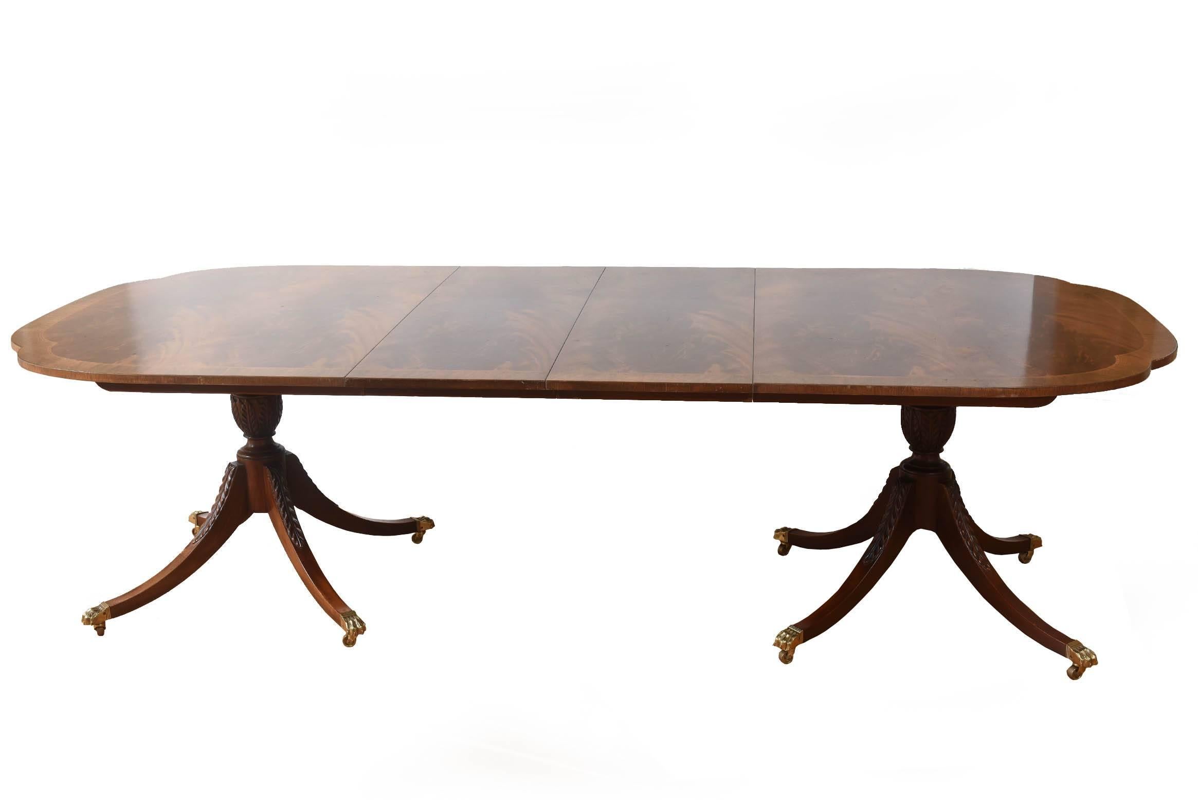 A classic and elegant dining room table with satinwood inlaid and twin pedestal bases. Wonderful flame mahogany veneer and featuring two leaves. Very nice vintage condition and ready for the holidays!
Dining table having shaped banded inlaid top on