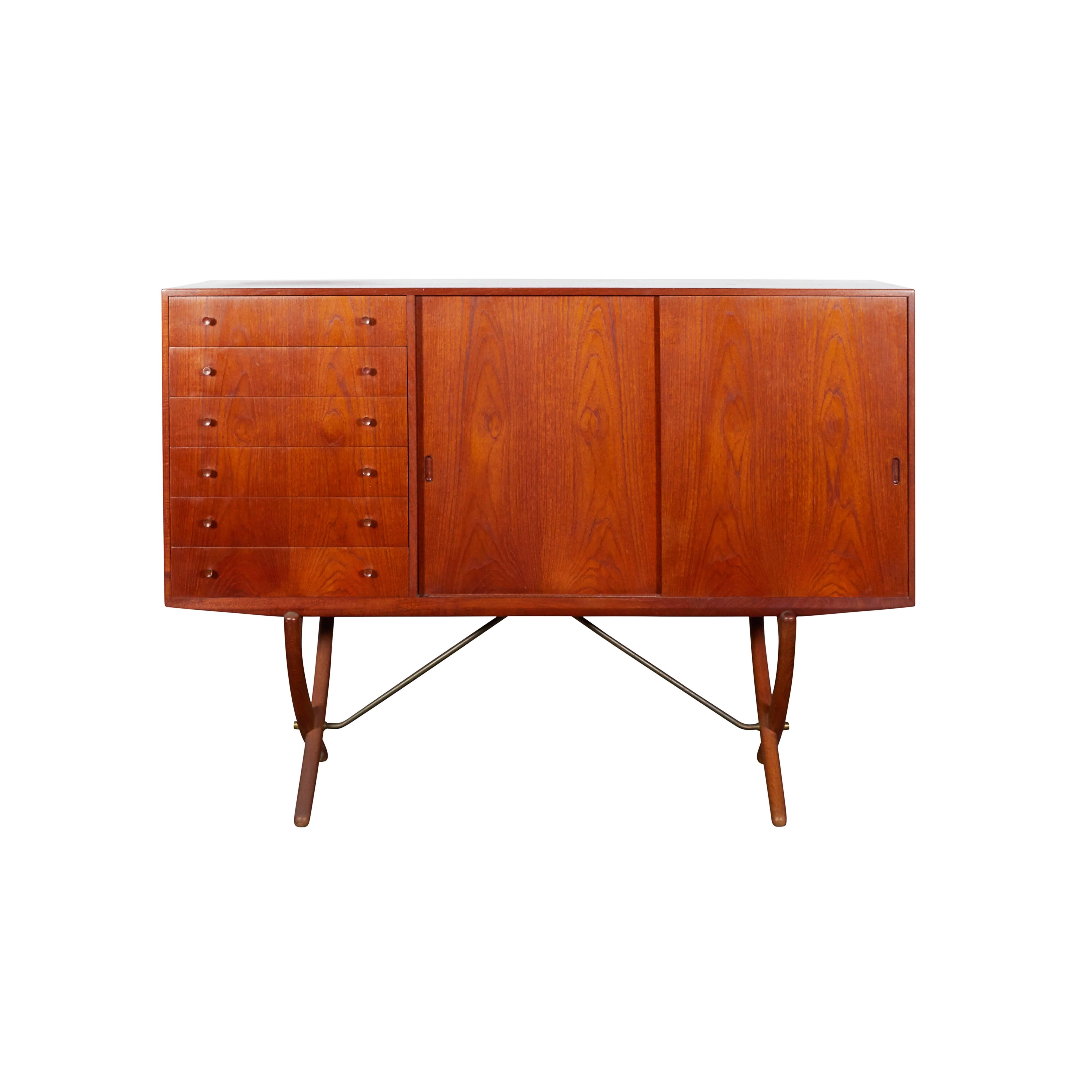 Vintage 1950s Saber Leg Sideboard by Hans Wegner.

This Vintage Credenza is in excellent condition. Six exterior drawers and six interior drawers / trays on the right side and 3 adjustable shelves on the left side all behind the two sliding doors.