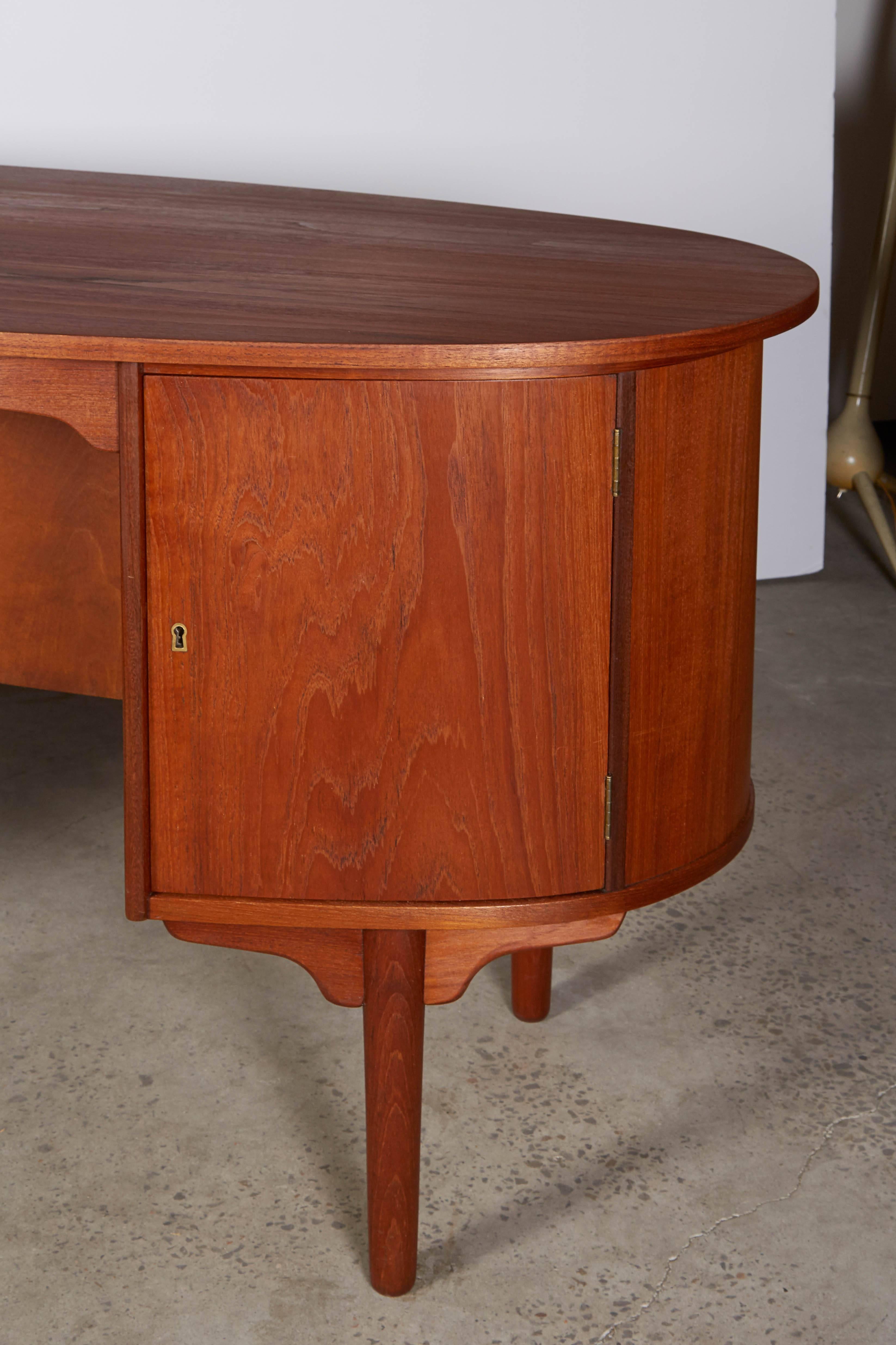Vintage 1960s Danish Vintage Desk with Rounded End

This Danish Desk in in like new condition. The top of the desk is in the shape of a bullet. Simply looking at it's construction you can see that it's beautifully built to last!  In addition it's