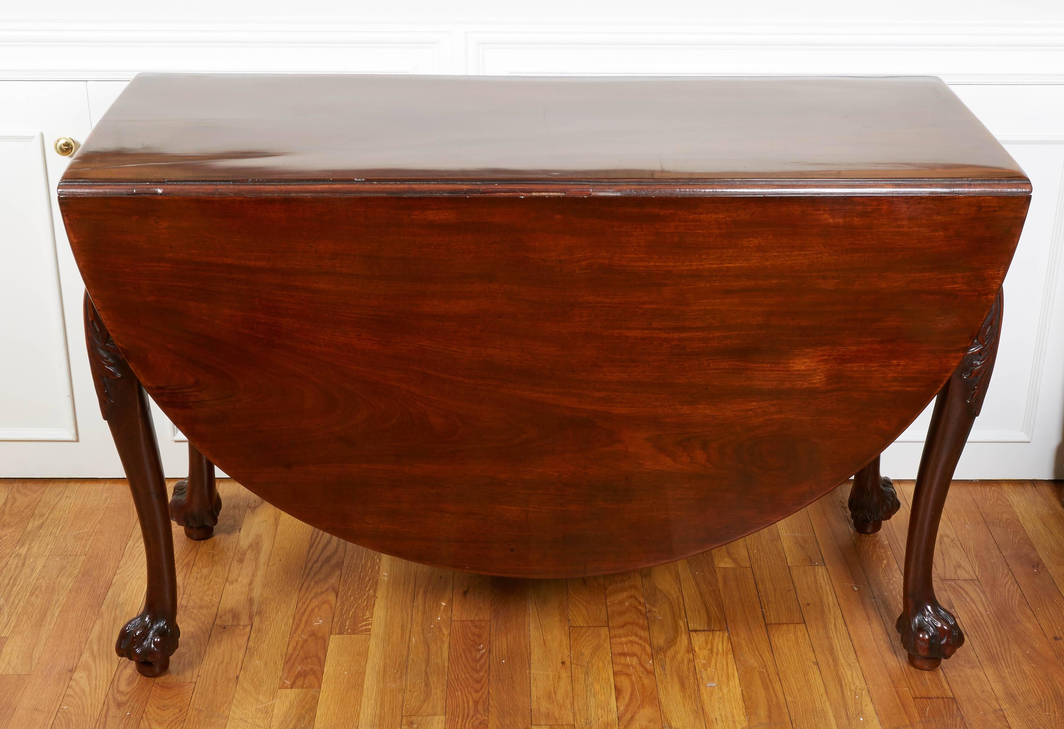 A George II mahogany drop-leaf table, the cabriole legs with bold acanthus carving, terminating in a hairy paw foot, circa 1760.